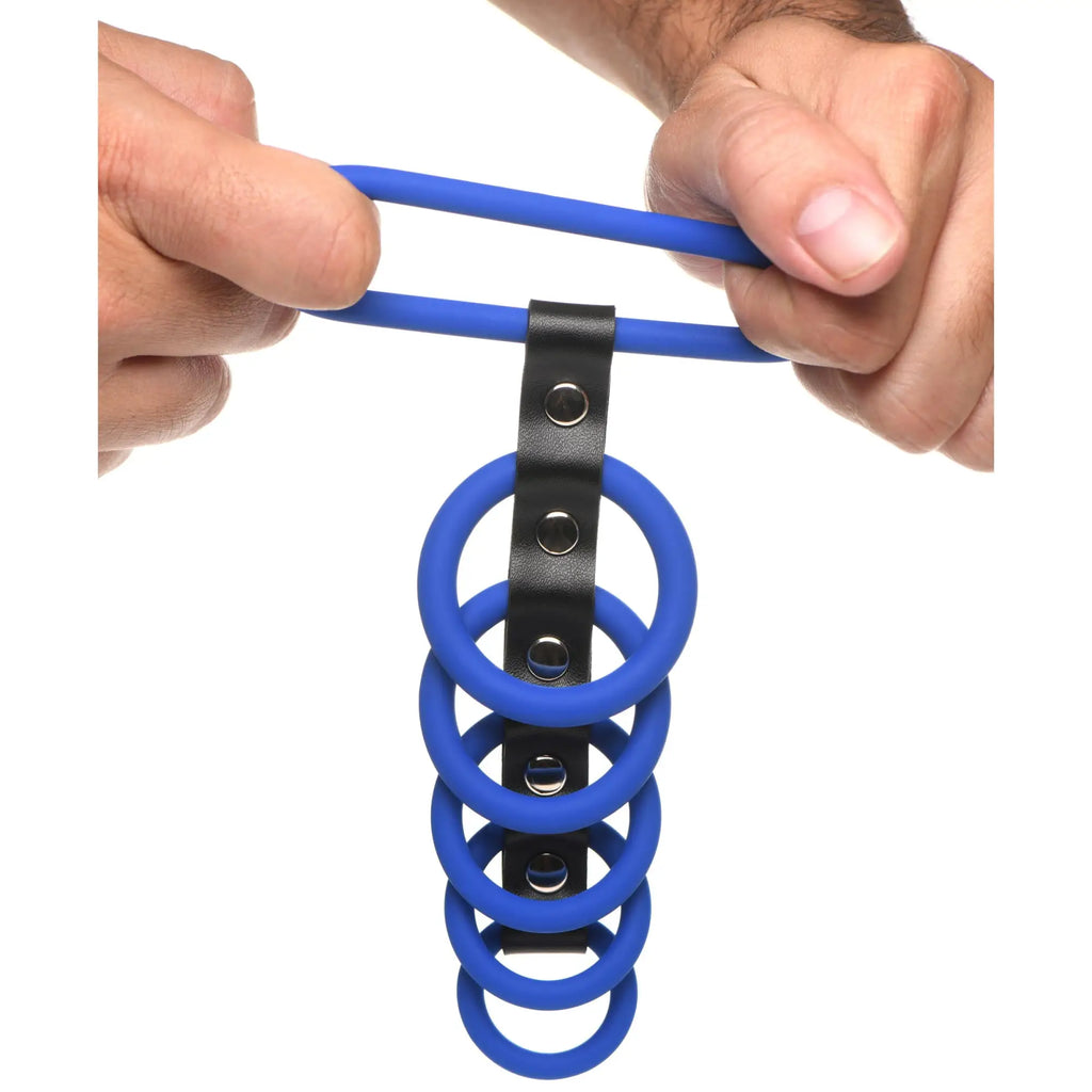 Strict Silicone Gates of Hell device: blue silicone rings attached to a black leather strap with metal snap buttons.