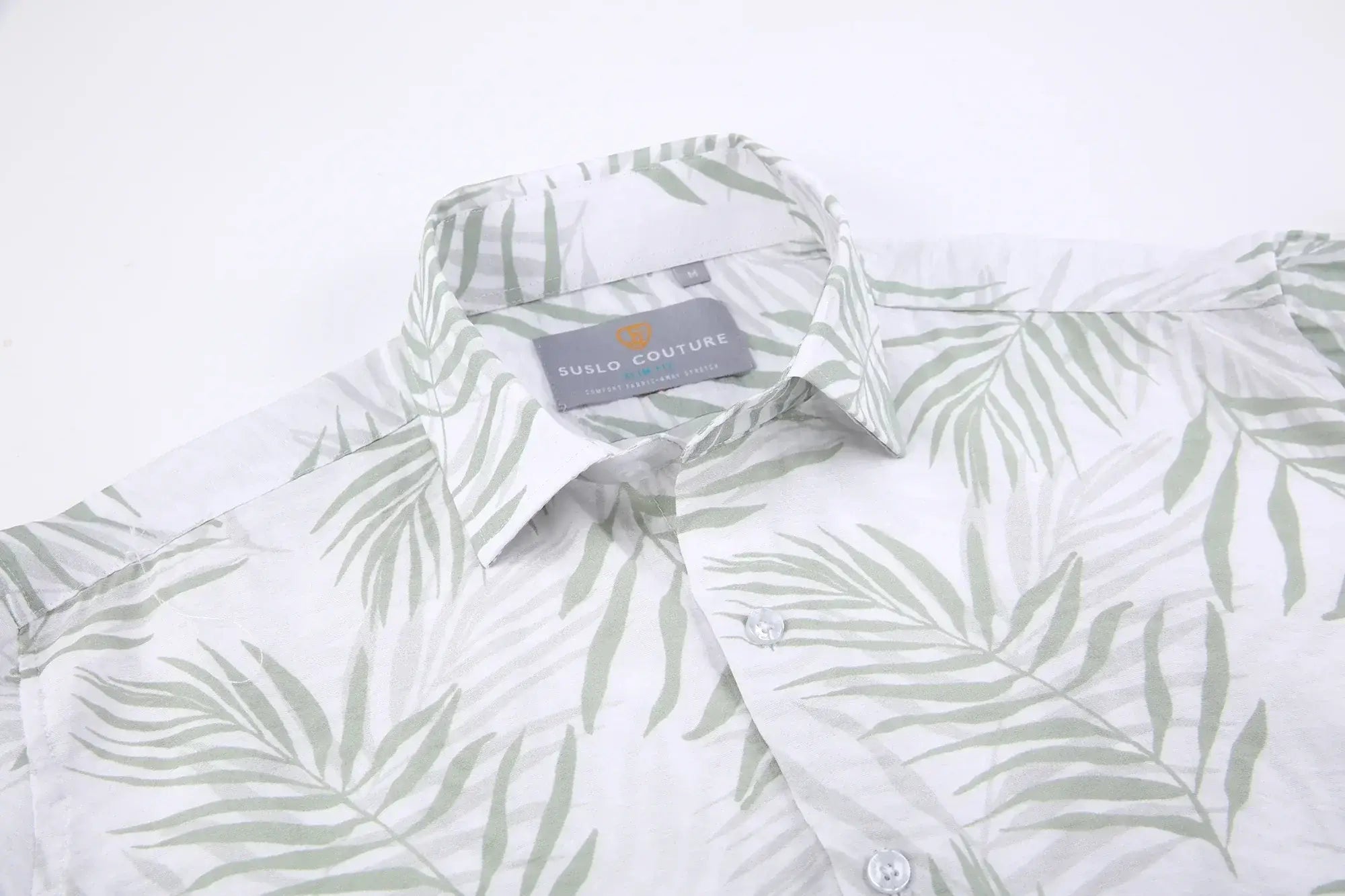 A white summer rain s s shirt with subtle green palm leaf pattern and suslo couture label at the collar