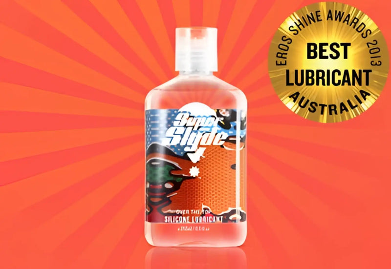 Clear plastic bottle of superslyde silicone lubricant with white cap and colorful label featuring cartoon characters