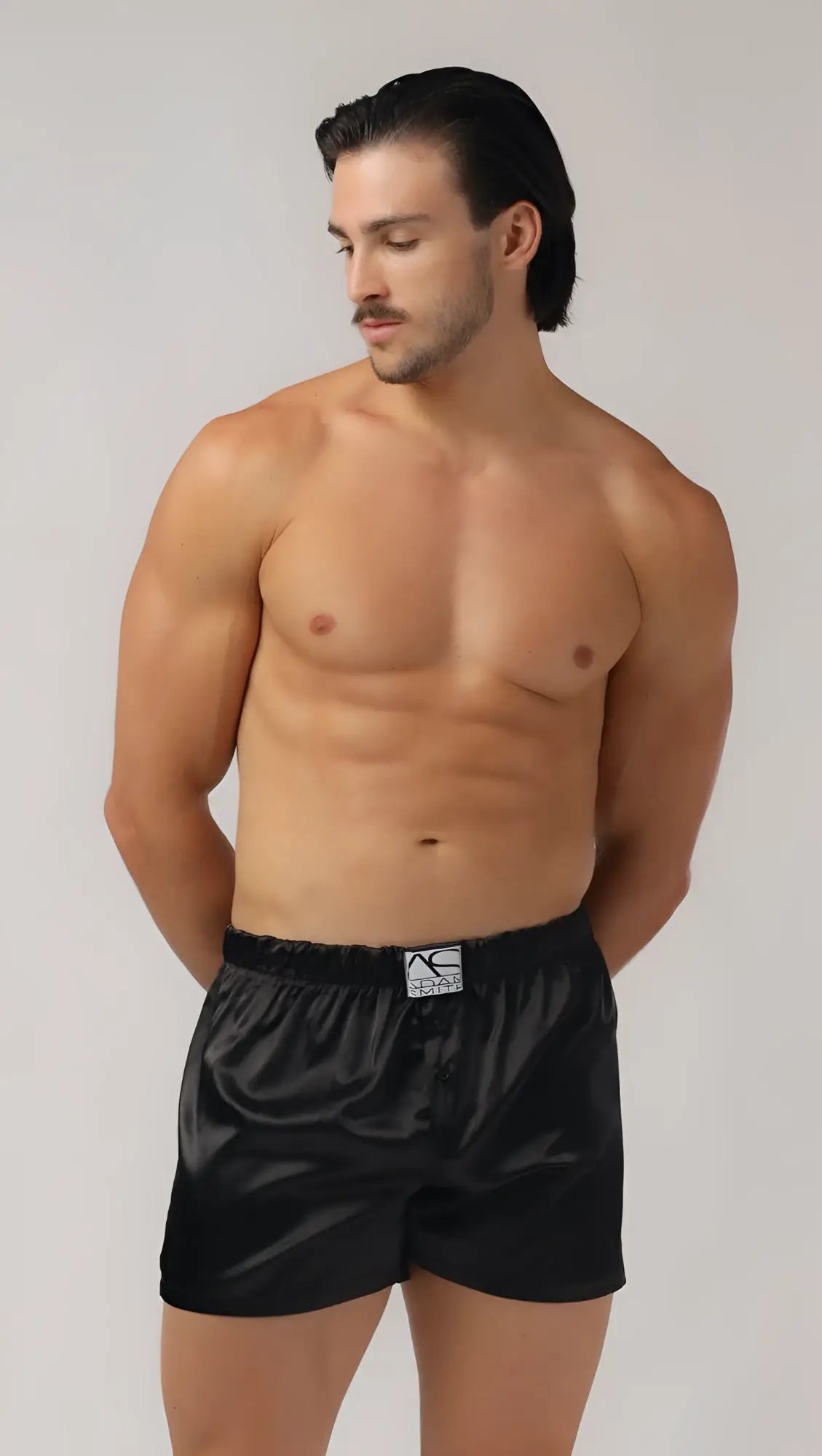 Black satin sweetheart boxer shorts with subtle sheen and small white logo on waistband front view
