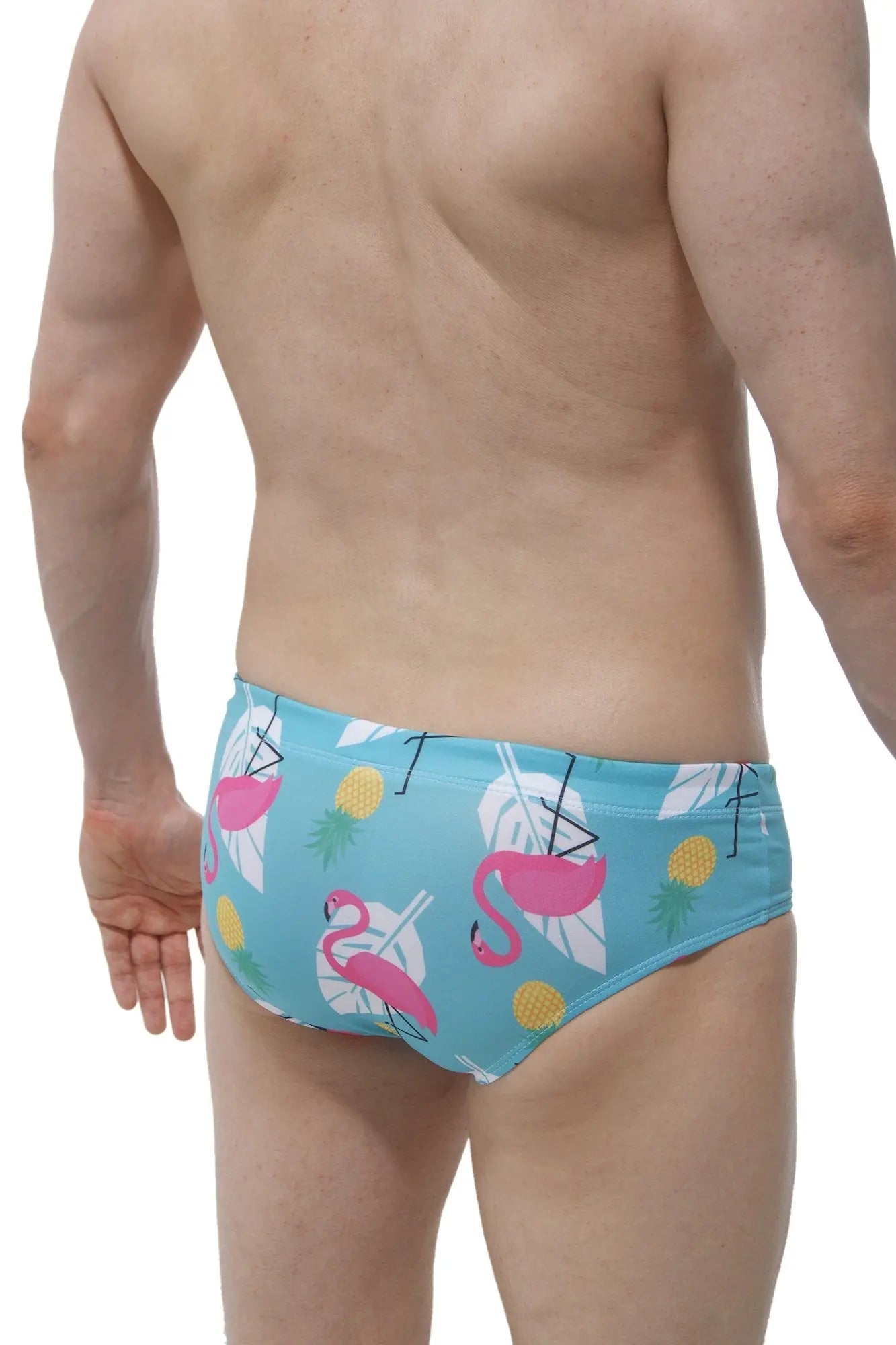 Light blue swim brief pina colada with male cup pad featuring pink flamingos white tropical leaves and yellow pineapples pattern