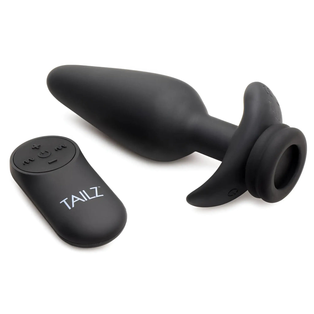 Tailz black silicone vibrating anal plug with a curved base and matching remote control, isolated on a white background.