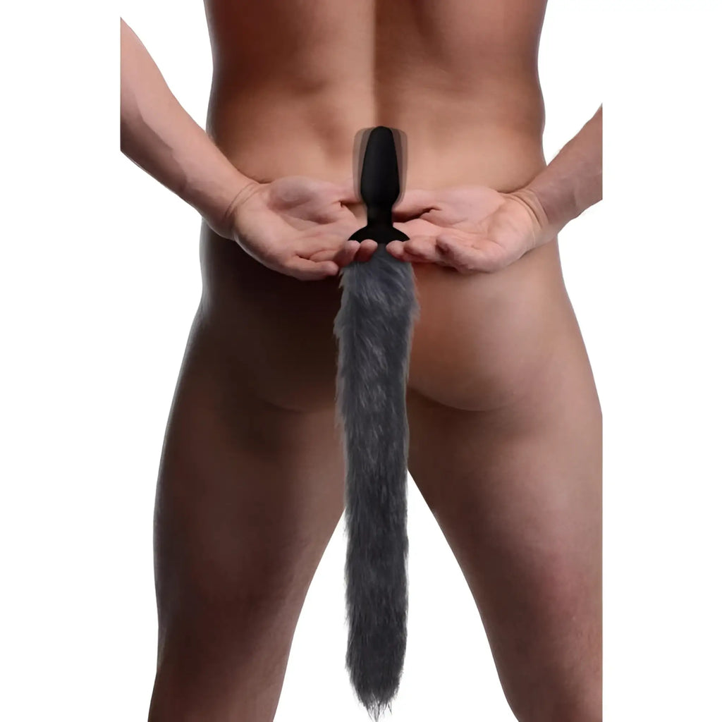 Tailz remote control vibrating anal plug with a long, fluffy grey faux fur fox tail, worn by a man from behind.