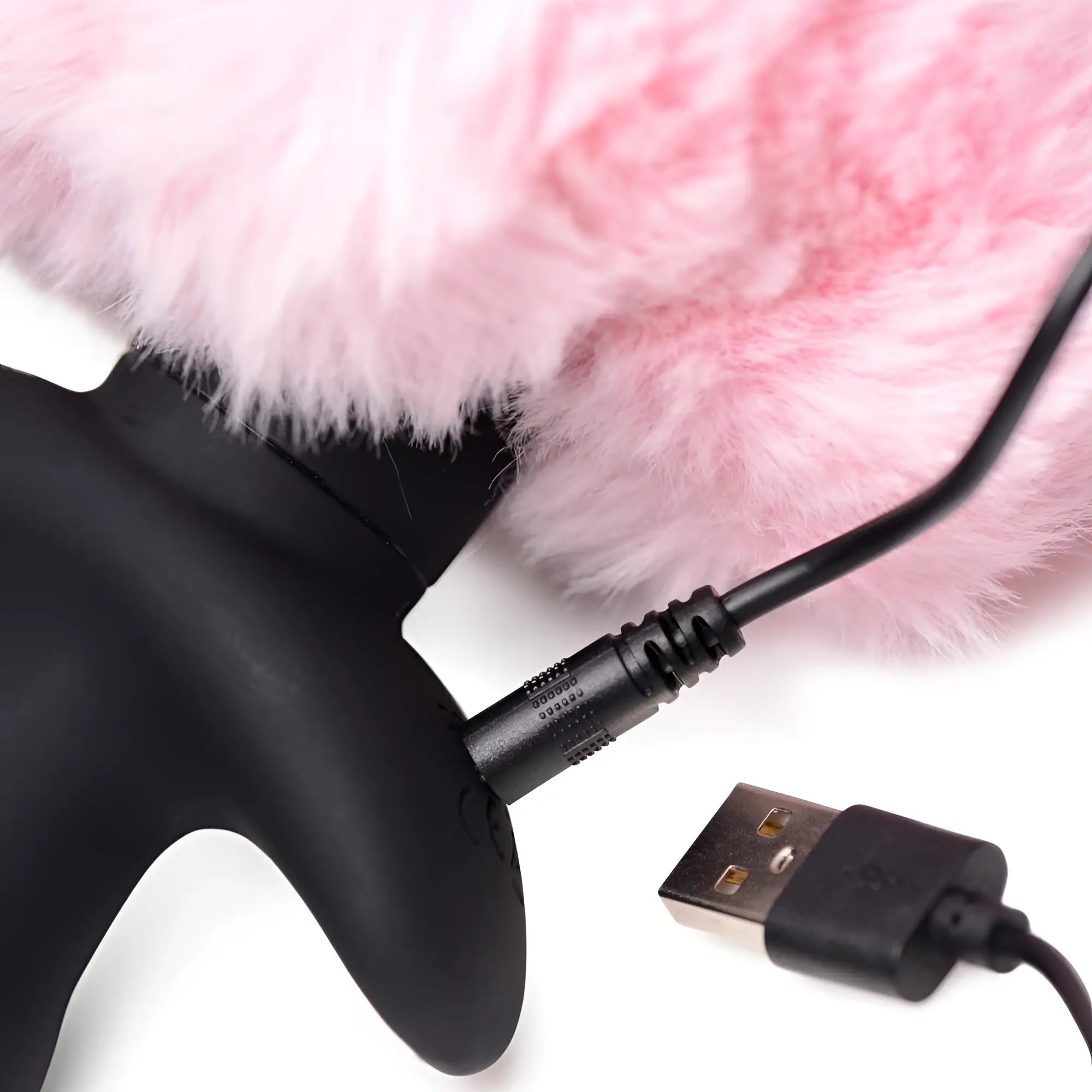 Tailz remote control wagging bunny tail anal plug showing a black silicone base being charged with a USB cable.
