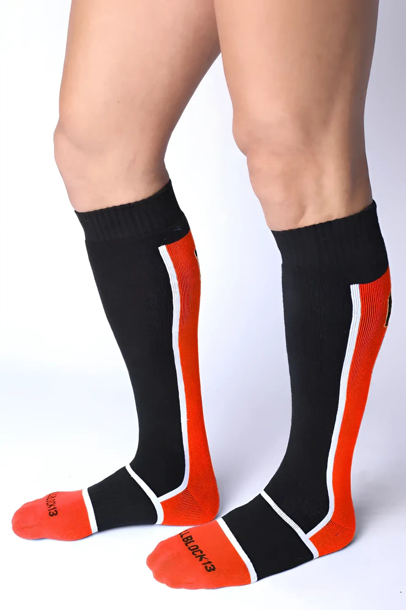 Take down knee high sock in black and orange with white trim ribbed texture and black & red brand name on foot