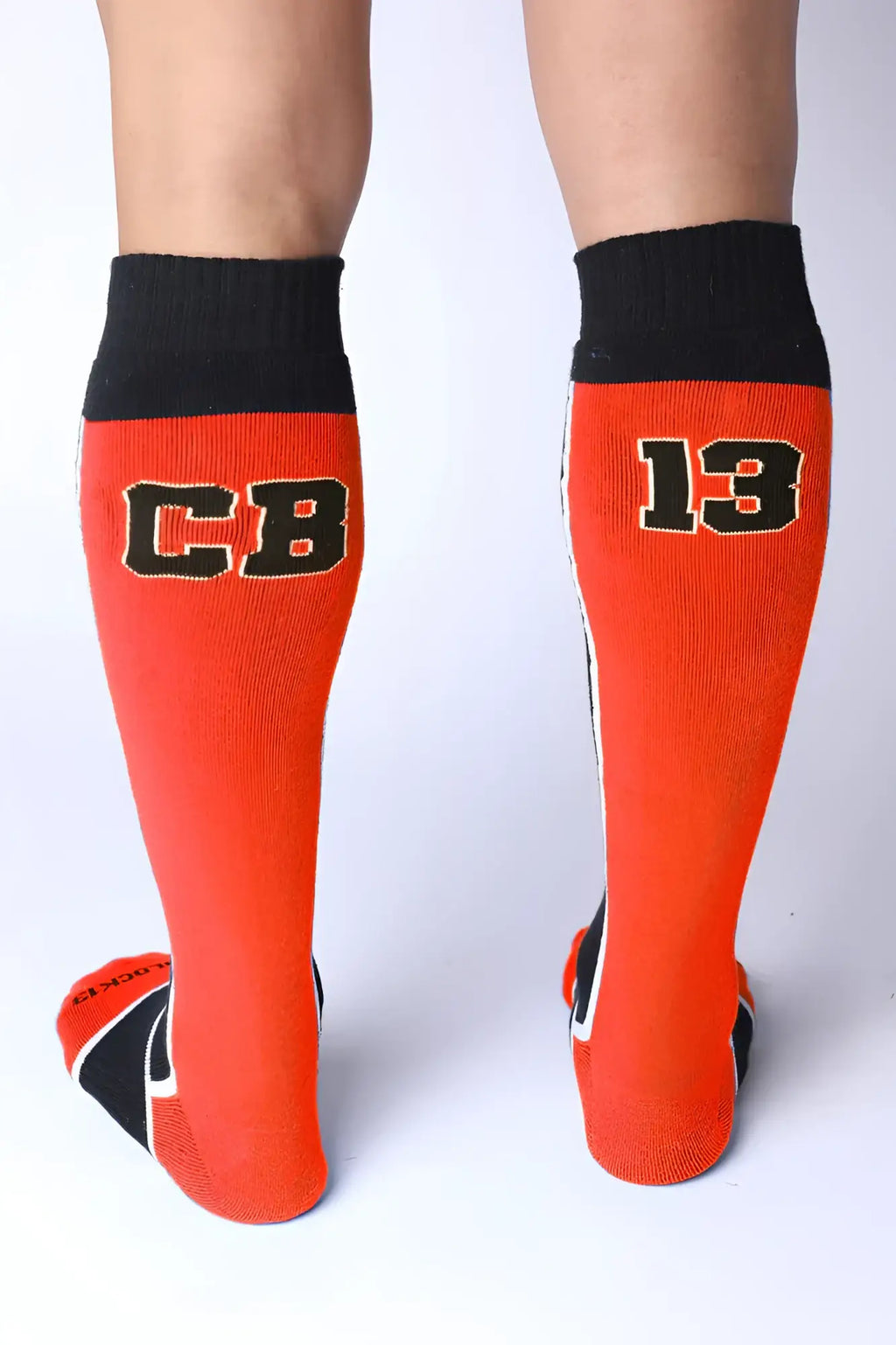 Take down knee high socks in bright orange with black ribbed cuffs toe accents and bold cb and 13 lettering