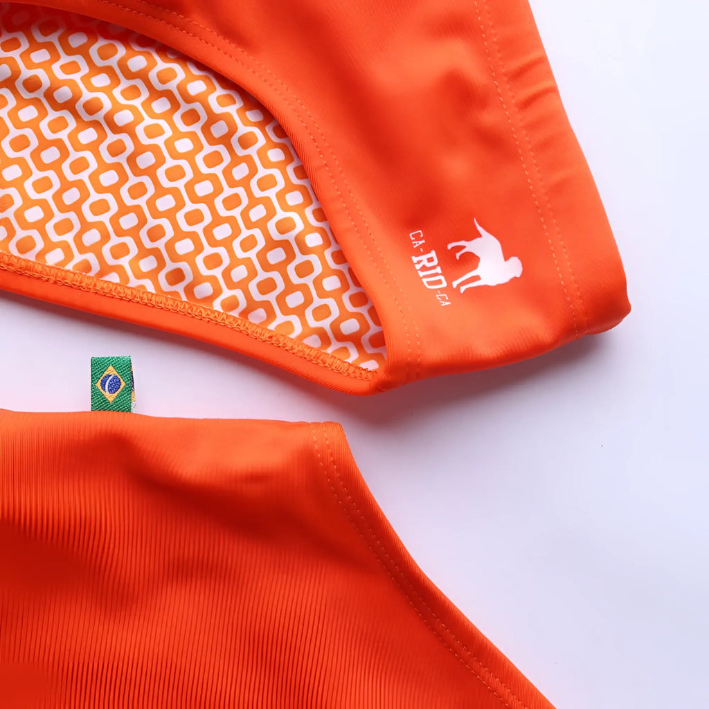 Bright orange men’s swimming sunga with white geometric inner lining and small white logo for beachwear use