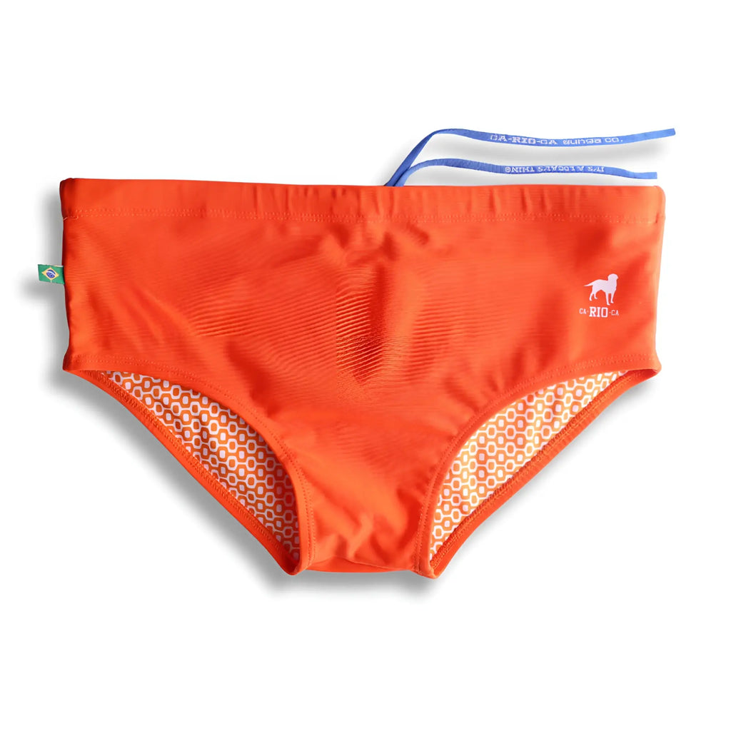 Bright orange mens swimming sunga with white dog logo rio text and beige cream patterned inner lining beachwear
