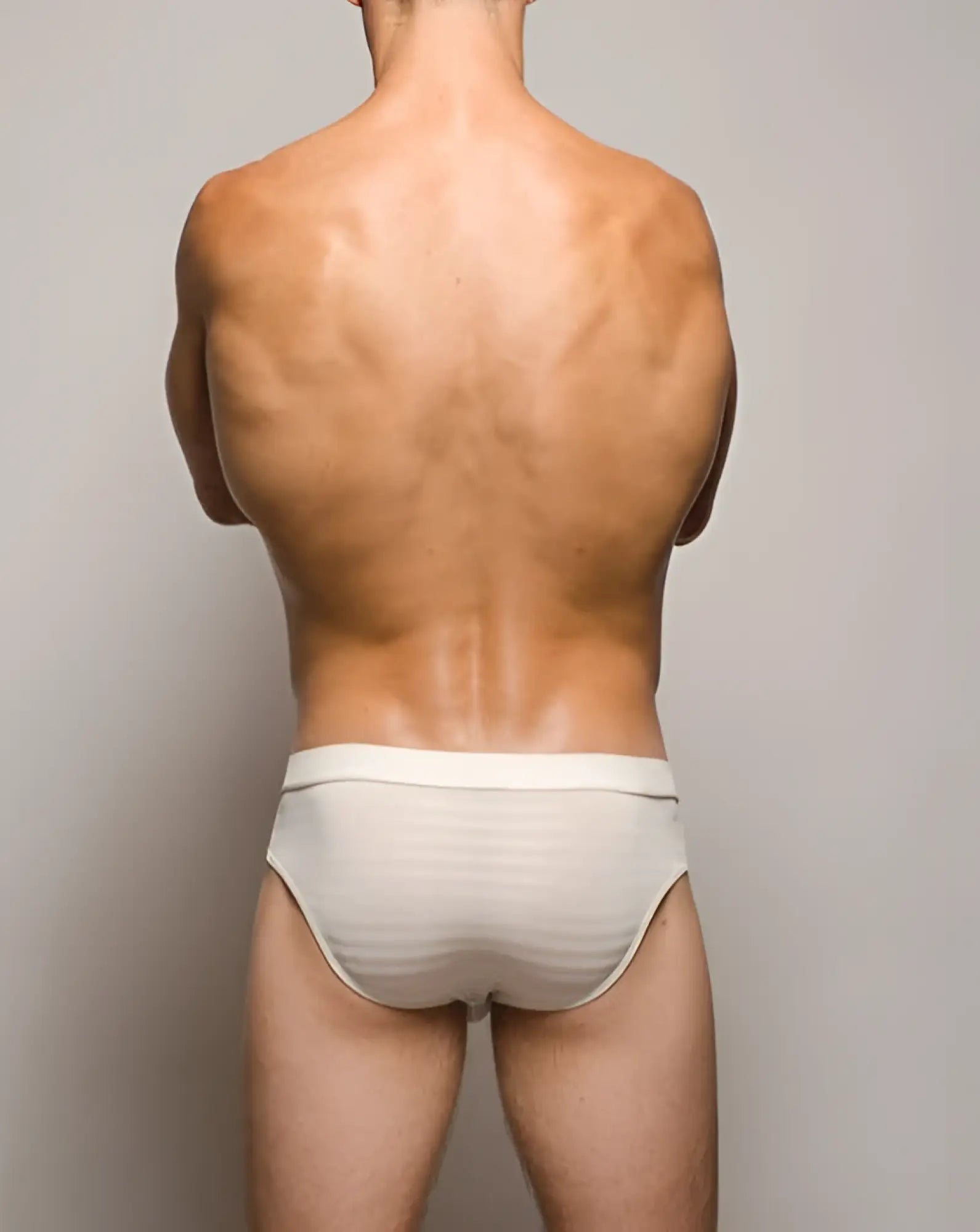 A pair of white tartarus buckle briefs with a subtle striped textured pattern