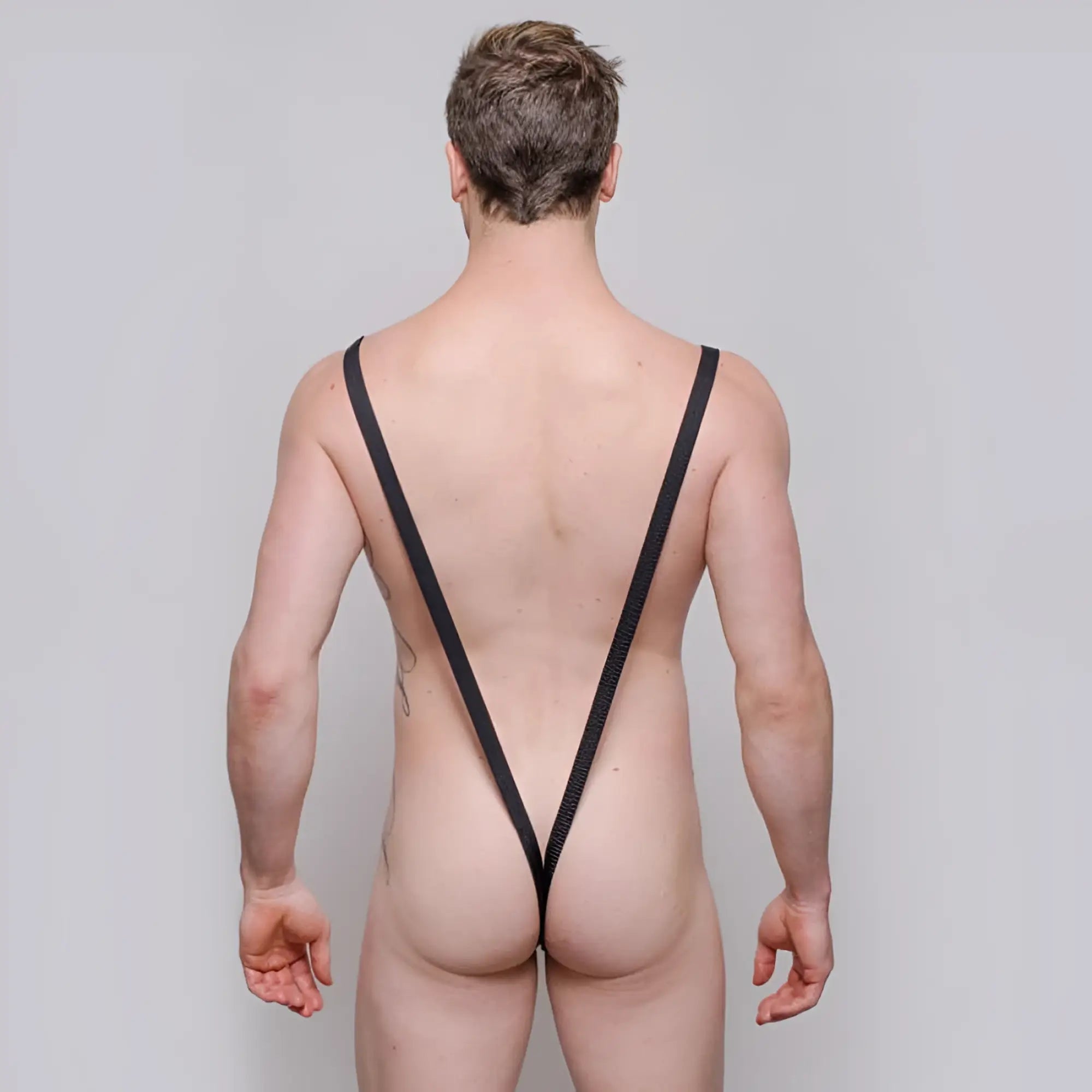 Black mesh strappy backless briefs shown from the back in tartarus sling shot body thong with rings design
