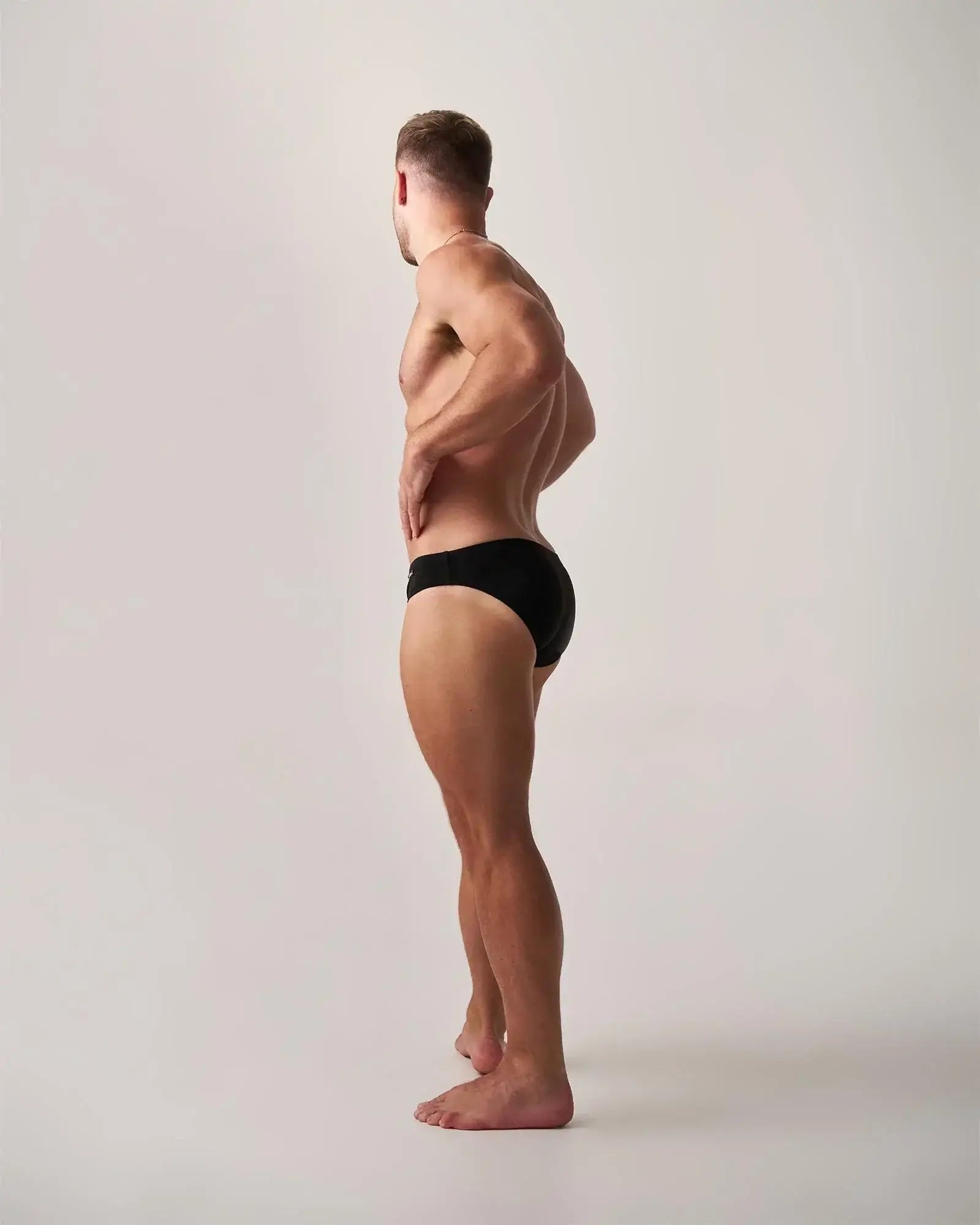 Black statement swim brief showing the back side in a sleek design for comfortable swimming and beachwear