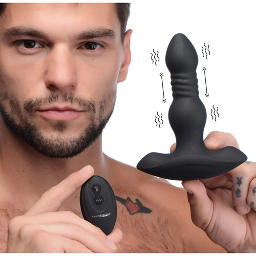 A man holds a black Thunderplugs silicone vibrating, thrusting anal plug and its matching remote control.