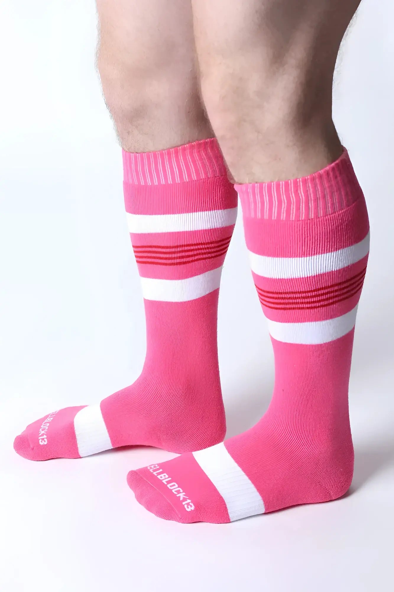 Tight end knee high socks in bright pink with bold white and red stripes featuring ribbed cuff and toe design