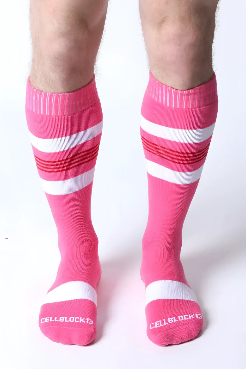 Bright pink tight end knee high socks with white and red stripes and the cellblock13 logo on the toe