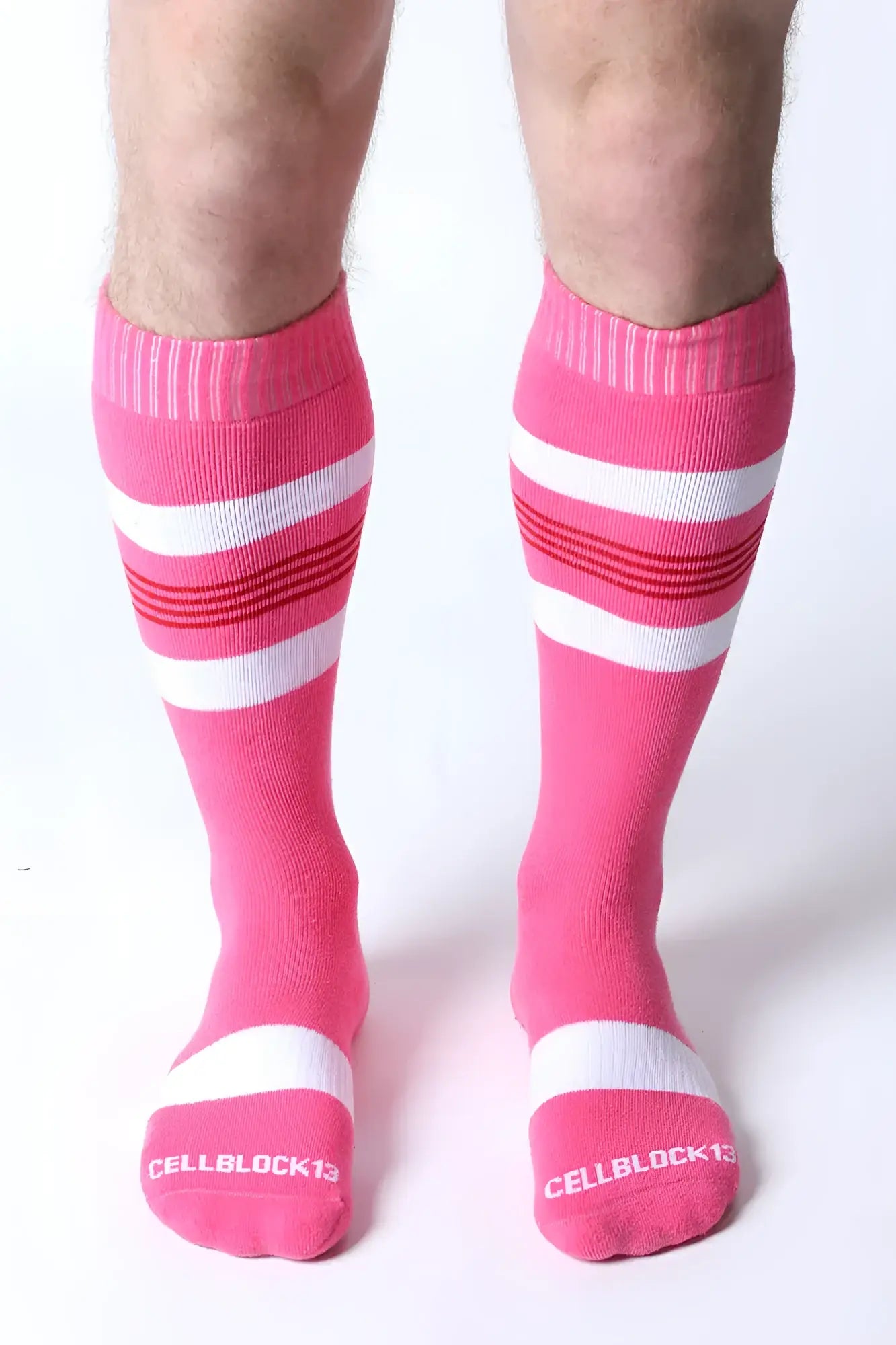 Bright pink tight end knee high socks with white and red stripes and the cellblock13 logo on the toe