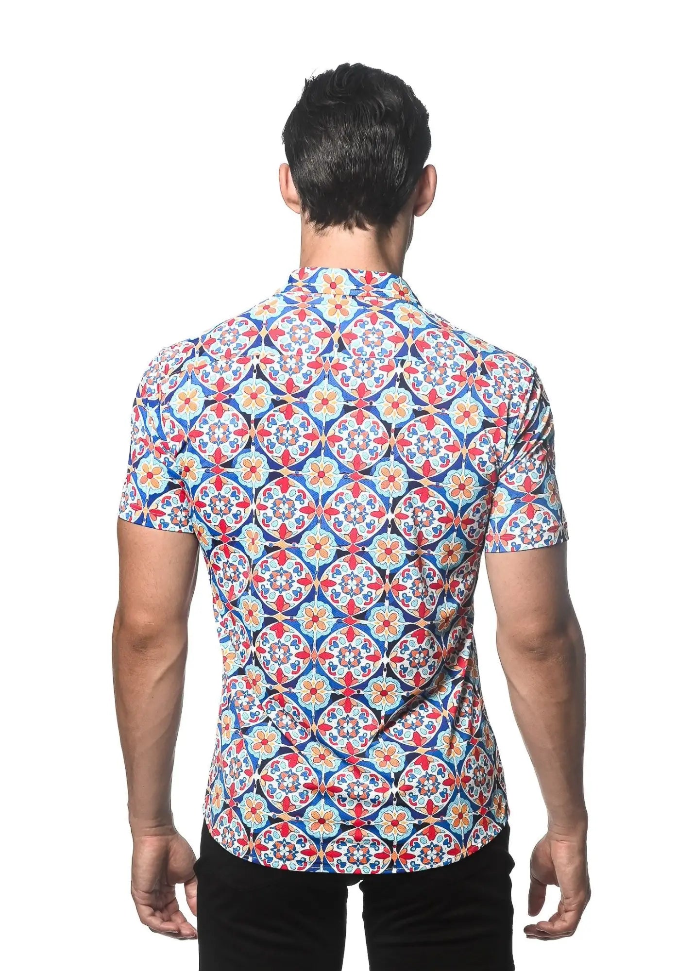 A man wearing a tile printed performance short-sleeved shirt with vibrant red blue and cream geometric pattern and contrast placket