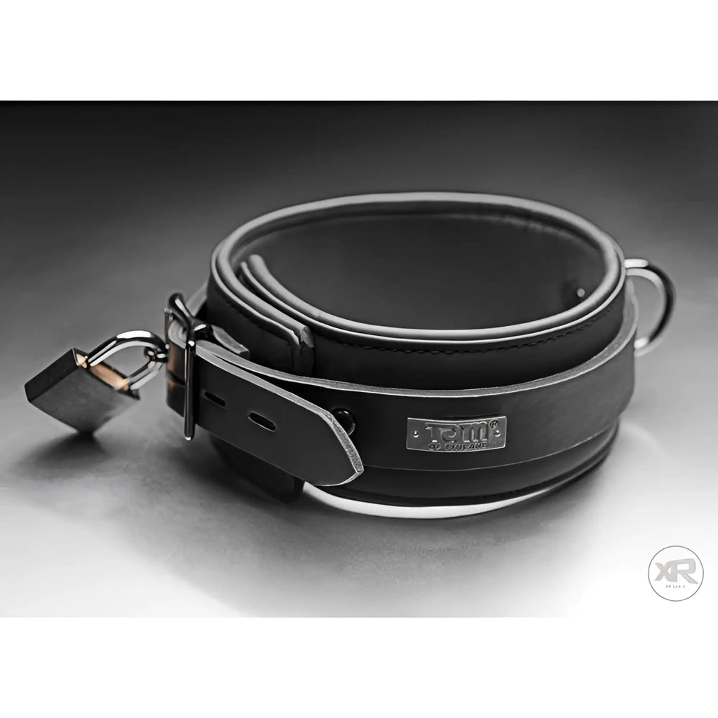 Black Tom of Finland neoprene collar with a metal buckle, silver brand plaque, D-ring, and a locking padlock.