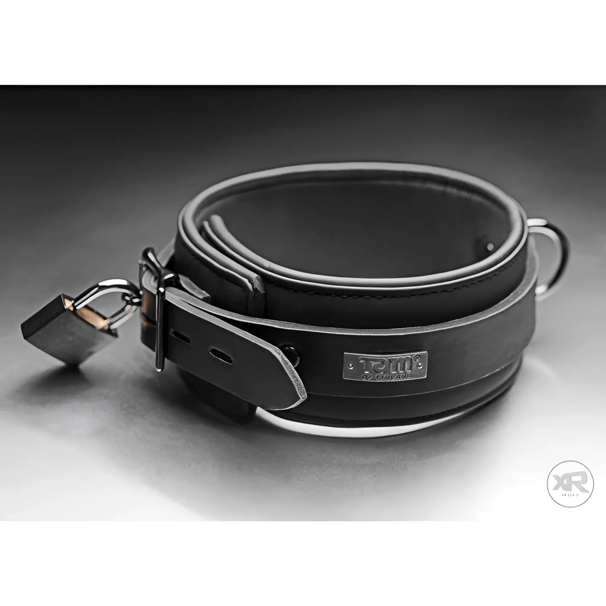 Black Tom of Finland neoprene collar with a metal buckle, silver brand plaque, D-ring, and a locking padlock.