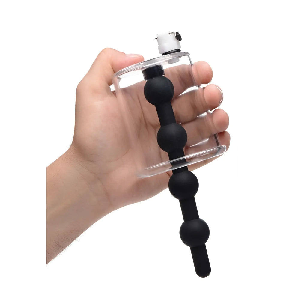 Hand holding a clear Tom of Finland Rosebud cylinder with a black, beaded silicone insert.