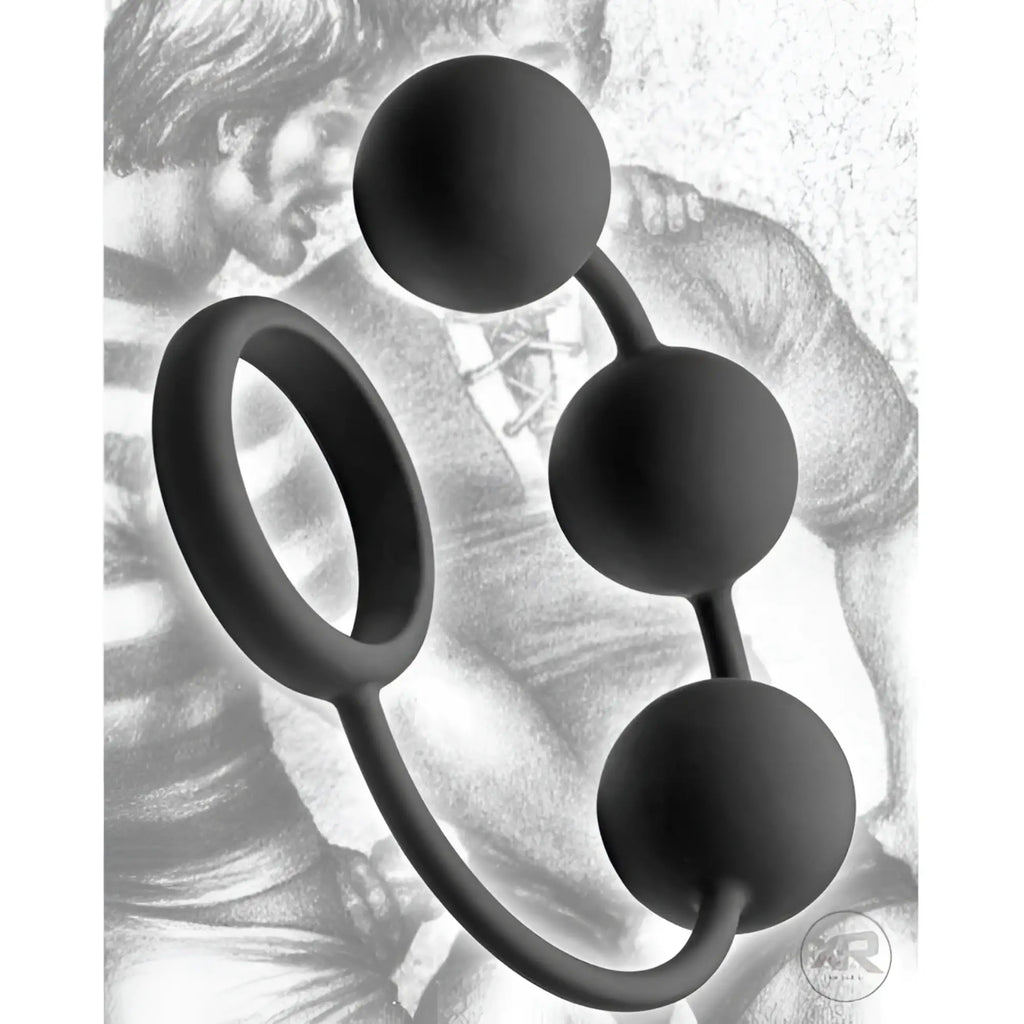Tom of Finland matte black silicone cock ring with three weighted anal balls, set against a sketched illustration background.