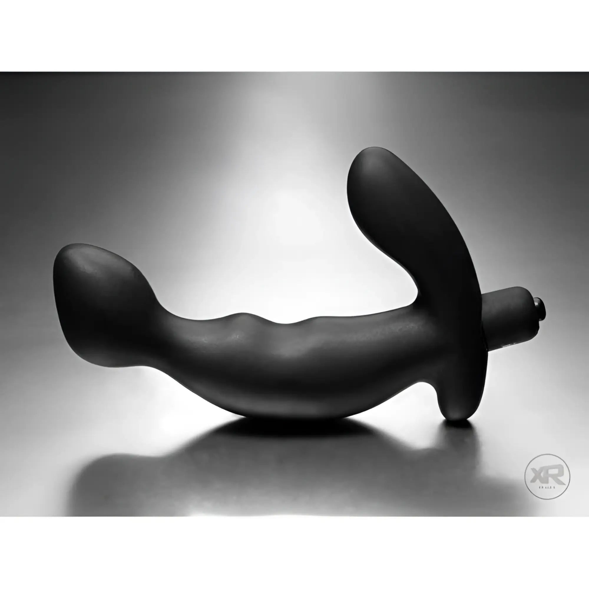 Tom of Finland silicone P-spot vibe: A matte black, curved, ergonomic prostate massager on a grey background.