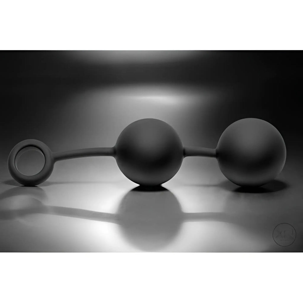 Tom of Finland weighted anal balls: two smooth, matte black spheres connected by a stem with a small pull ring.