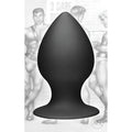 Tom of Finland XL matte black silicone anal plug shown in front of a monochromatic Tom of Finland illustration.
