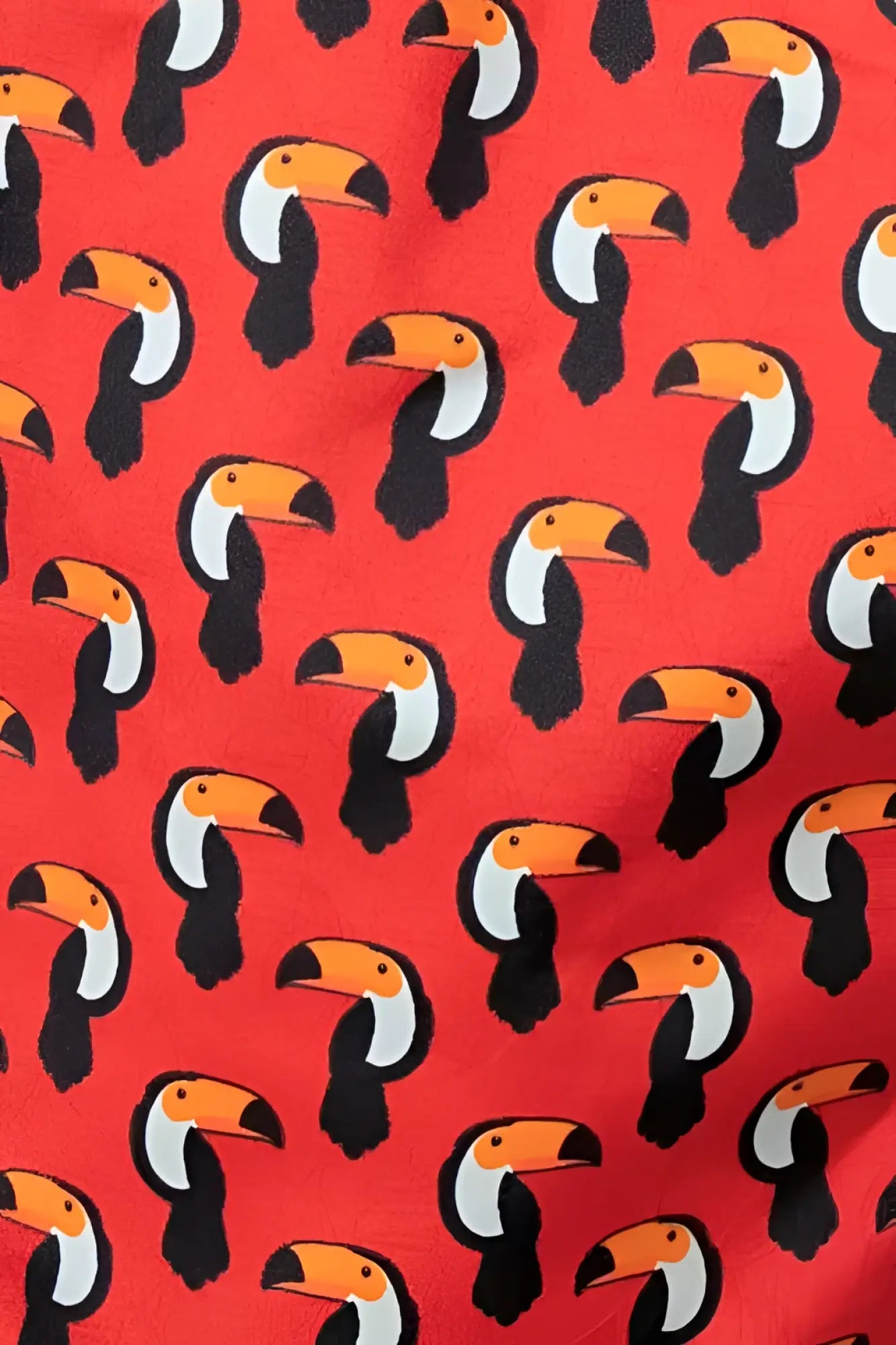 Red toucan print swim short featuring a repeating pattern of stylized black white and orange toucans on fabric