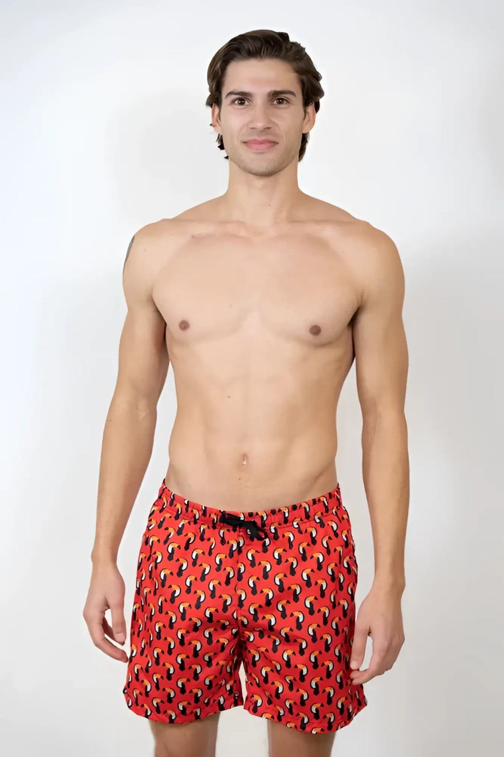 Red toucan print swim short with black and yellow abstract pattern designed for swimming and beachwear