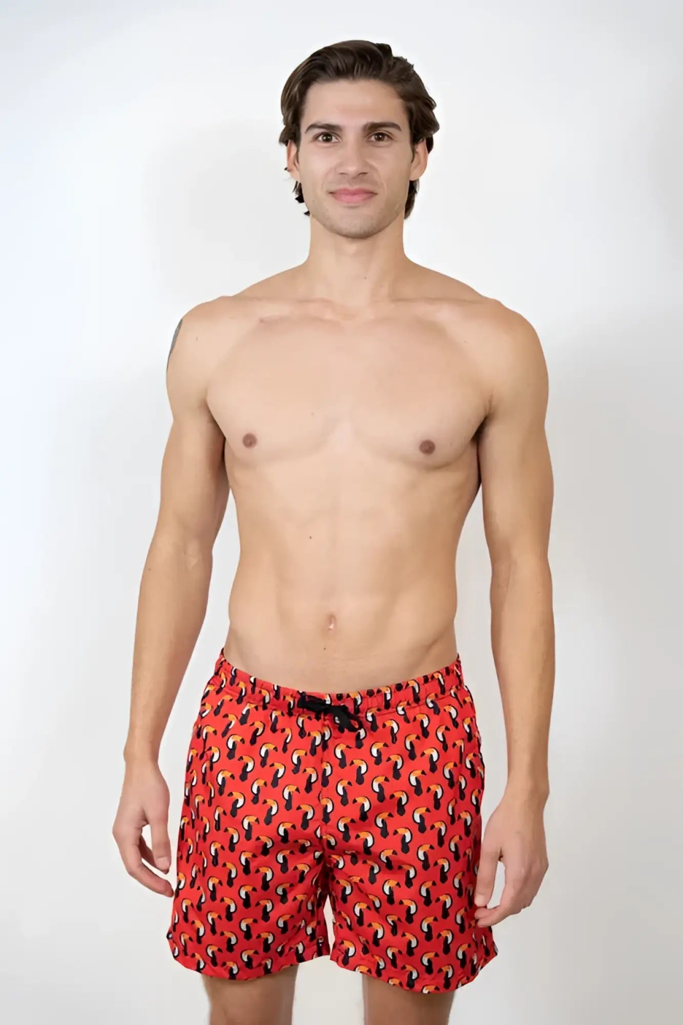 Red toucan print swim short with black and yellow abstract pattern designed for swimming and beachwear