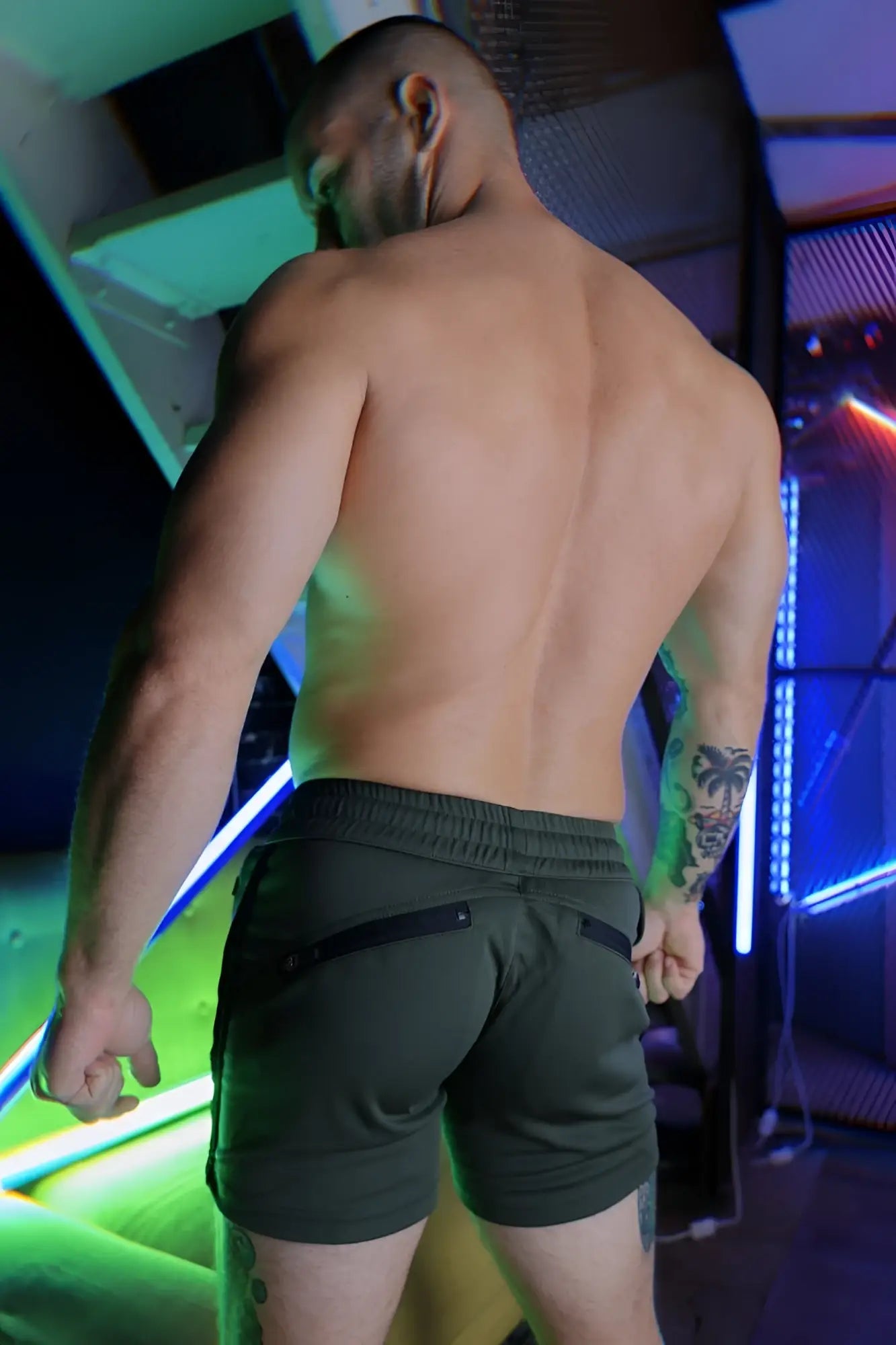 Olive green trade trainer shorts with black zipper pockets and elastic waistband for athletic use