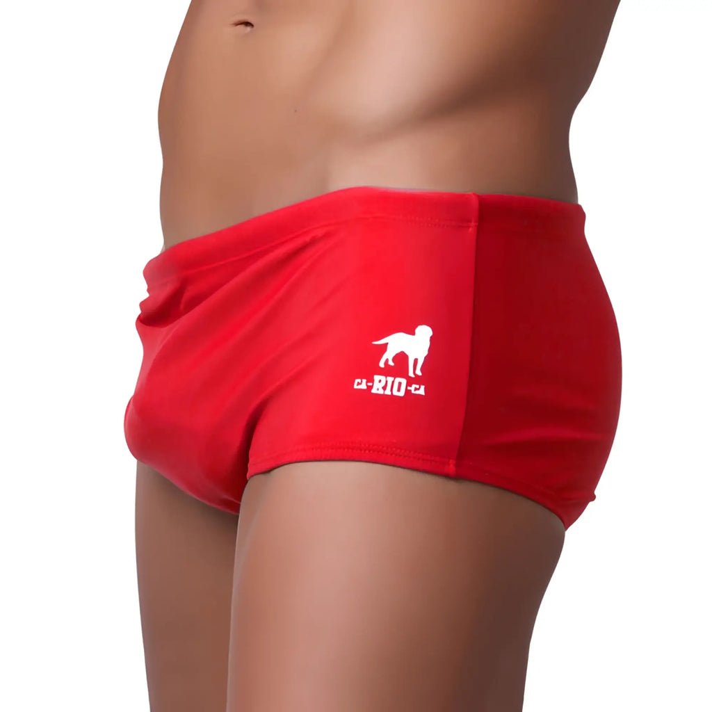 Traditional square solids cut sunga men’s red swim trunks with white dog logo and ca-rio-ca text on left leg