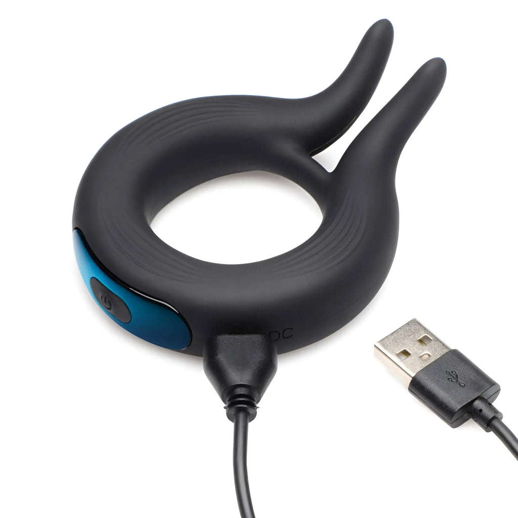 Trinity Men 10X dual-stim silicone cock ring in matte black with a blue power button and included USB charging cable.
