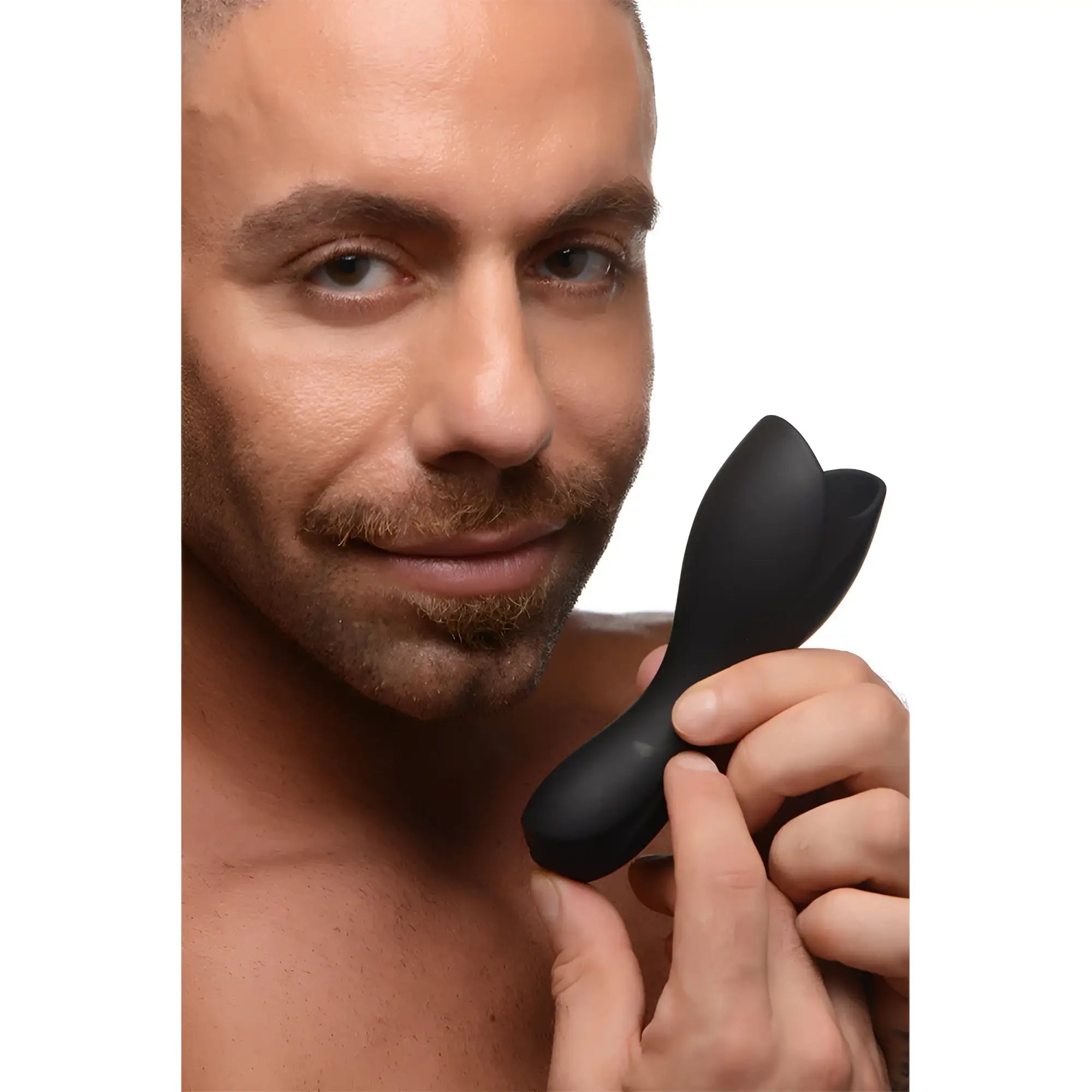 A man holds the black, petal-shaped Trinity Men 10X Vibrating Penis Head Teaser with urethral sound.