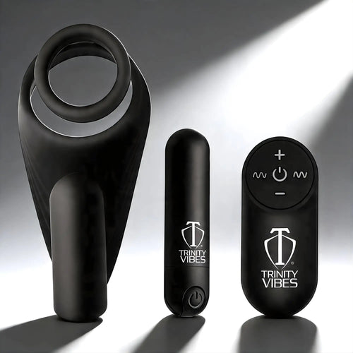 Trinity Men 7X black silicone c-ring with vibrating stimulator, power bullet, and remote control on a grey background.