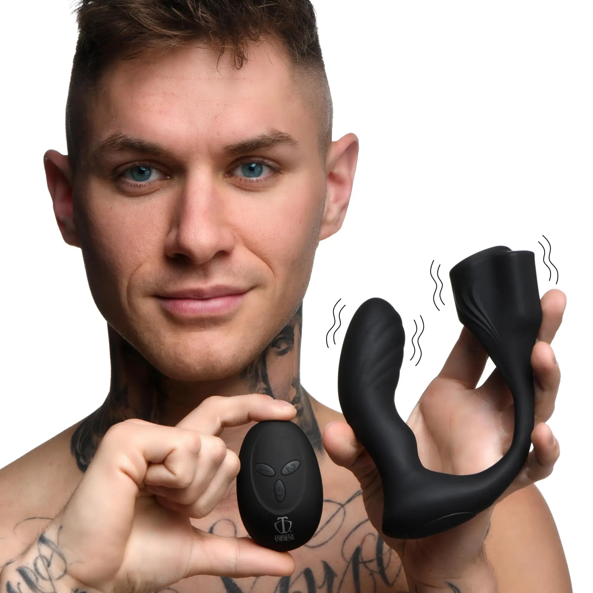 A man holds a black Trinity Men 7X silicone prostate plug with a ball stretcher and its remote control.