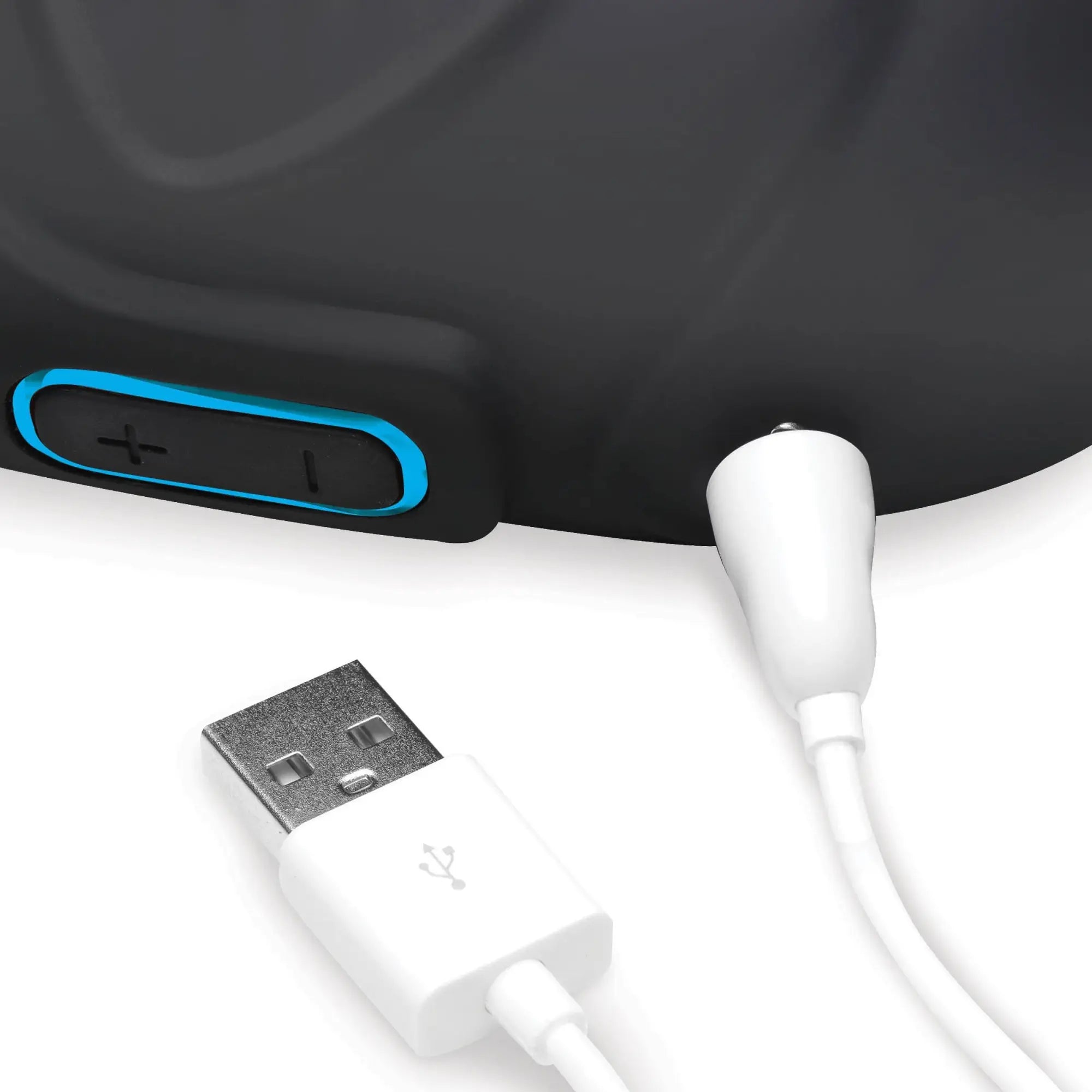 Trinity Men 7x silicone testicle massager in matte black, showing the charging port with a white USB cable connected.