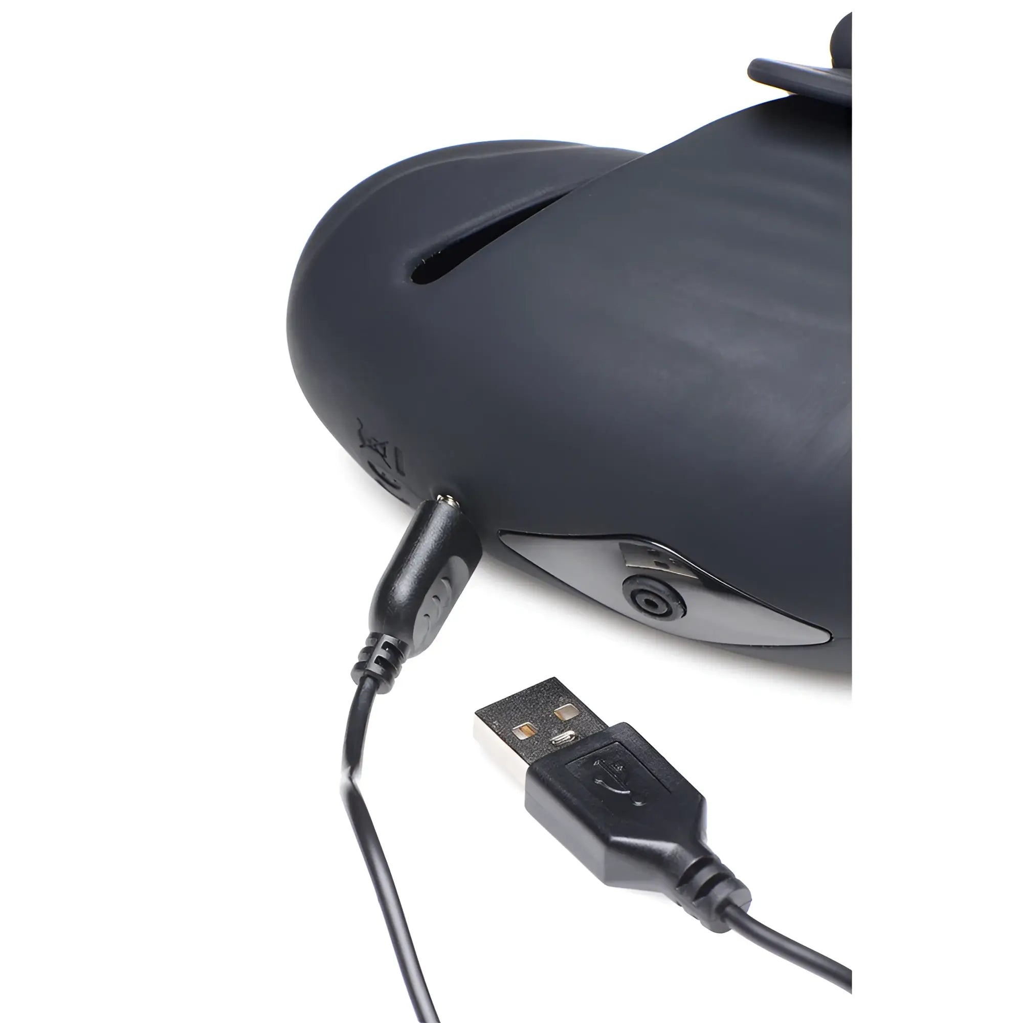 Trinity Men 8X black silicone head stimulator shown with a charging cable plugged into the device port.