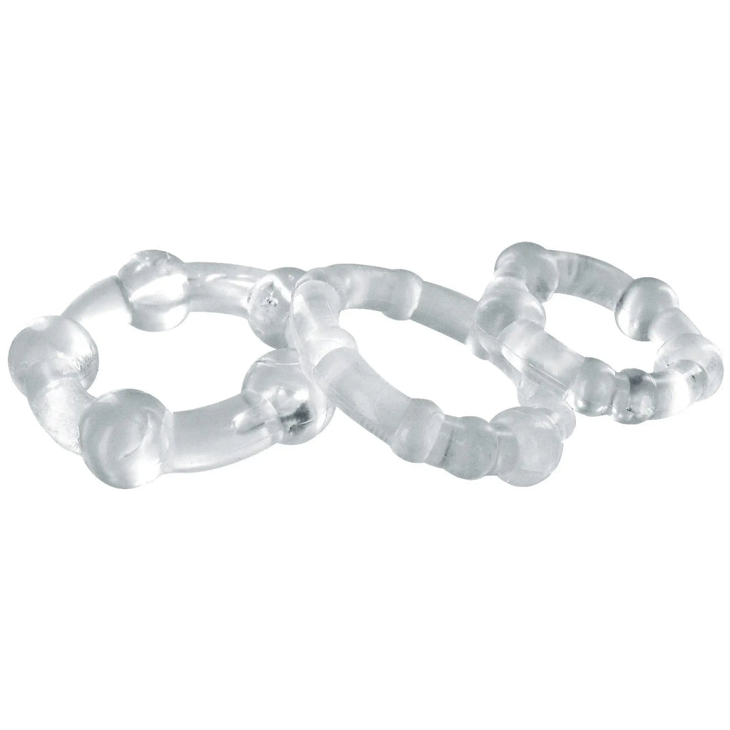 Three clear, textured Trinity Men Performance cock rings of varying sizes, arranged in an overlapping cluster.