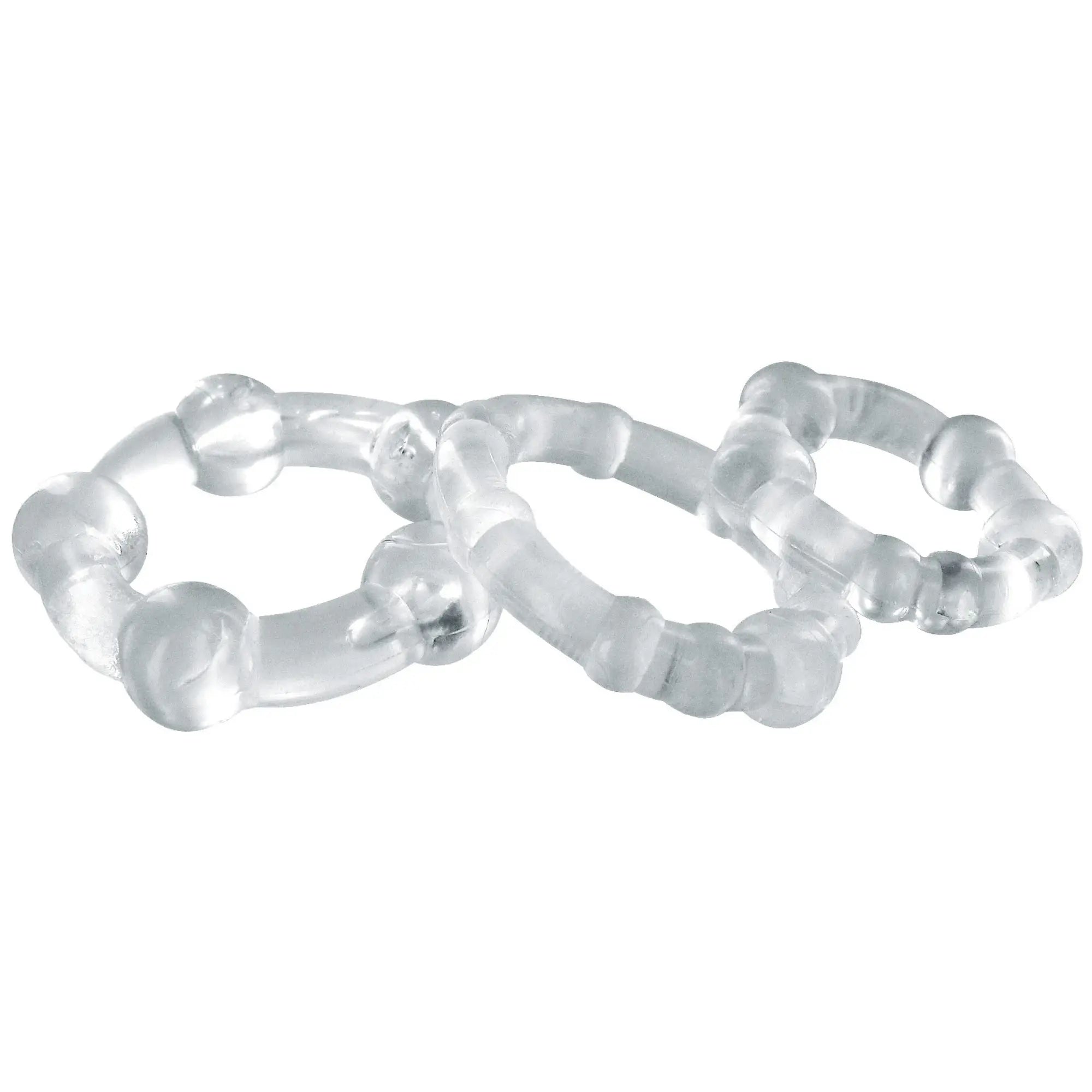 Three clear, textured Trinity Men Performance cock rings of varying sizes, arranged in an overlapping cluster.
