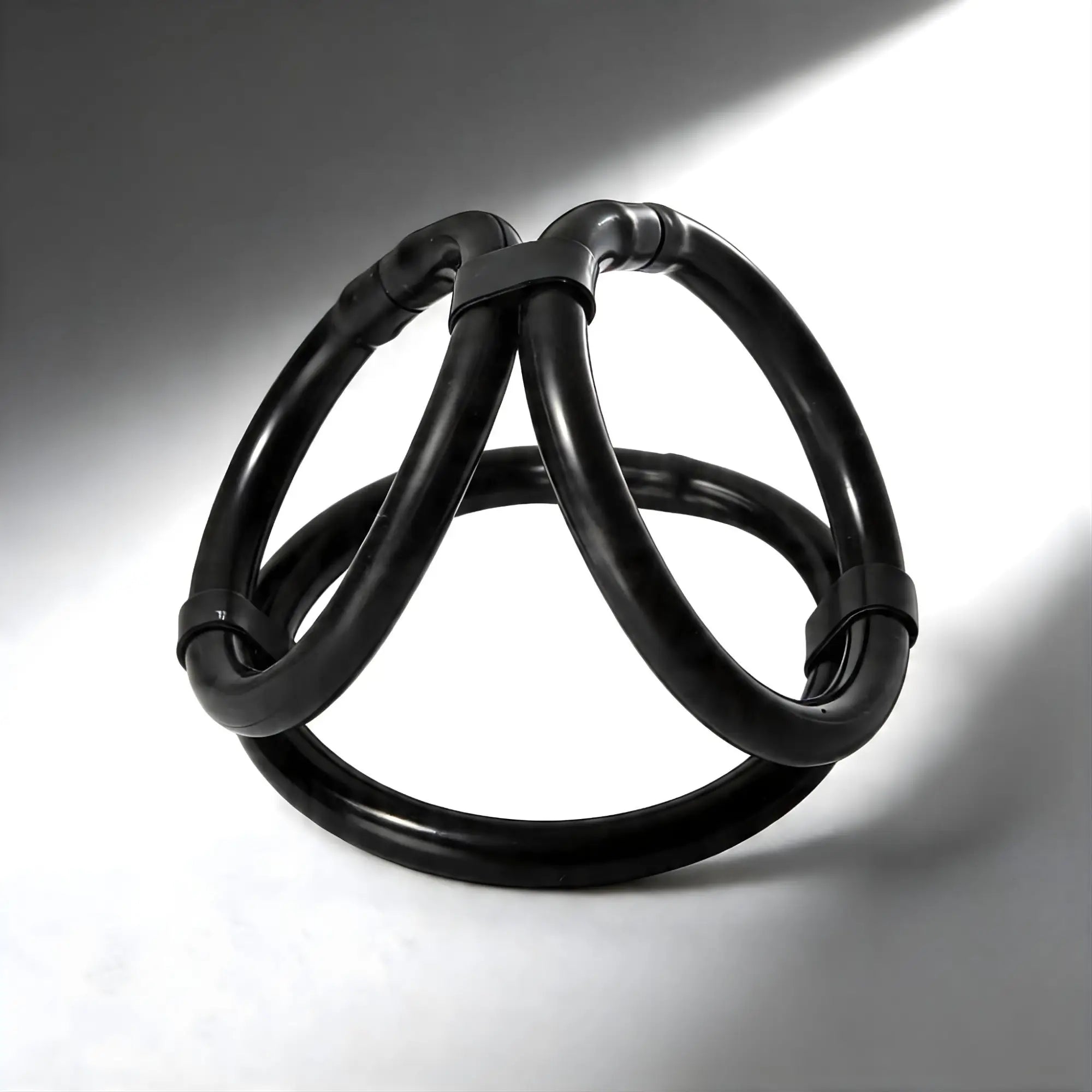Trinity Men Easy Release Tri-Cock-Ring: A glossy, black circular accessory with three intersecting loops.