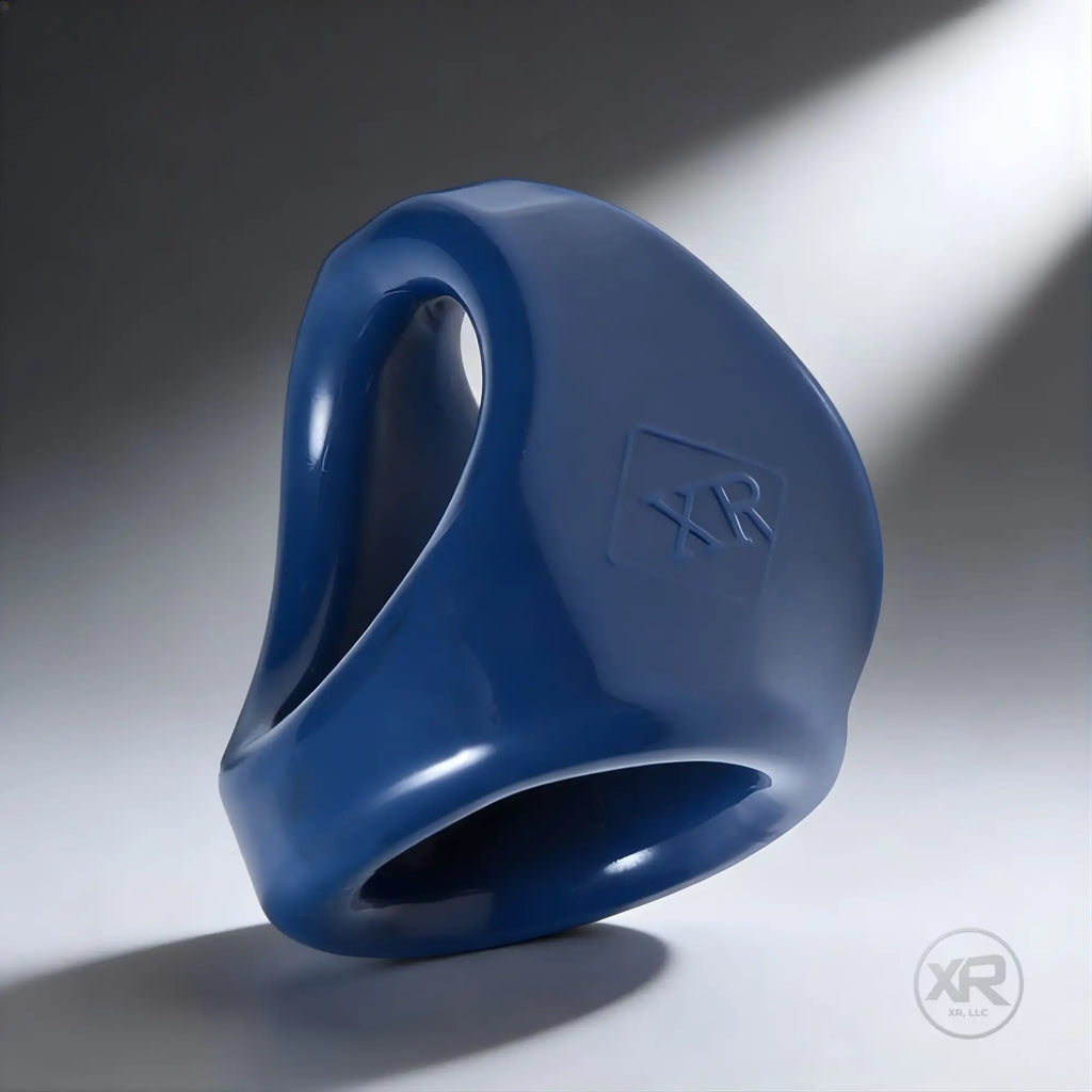 Trinity Men’s dual cock and ball ring in a smooth, dark blue silicone with an embossed XR logo on the side.