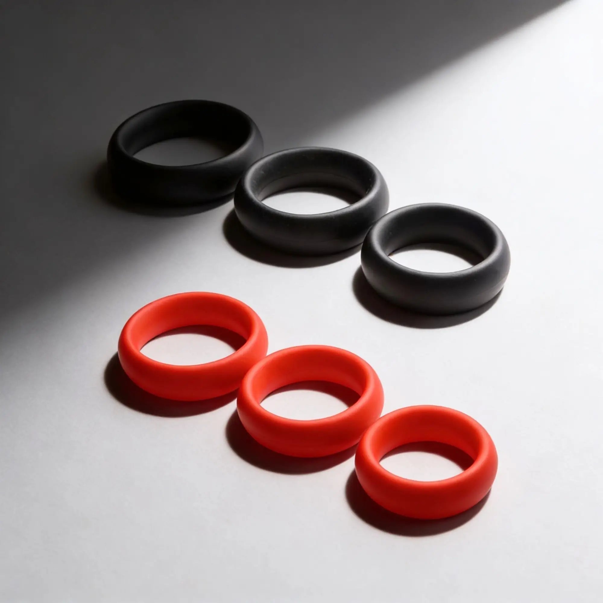 Trinity Men Fat Silicone Cock Ring 3-pack featuring three black and three bright orange thick, smooth silicone rings.