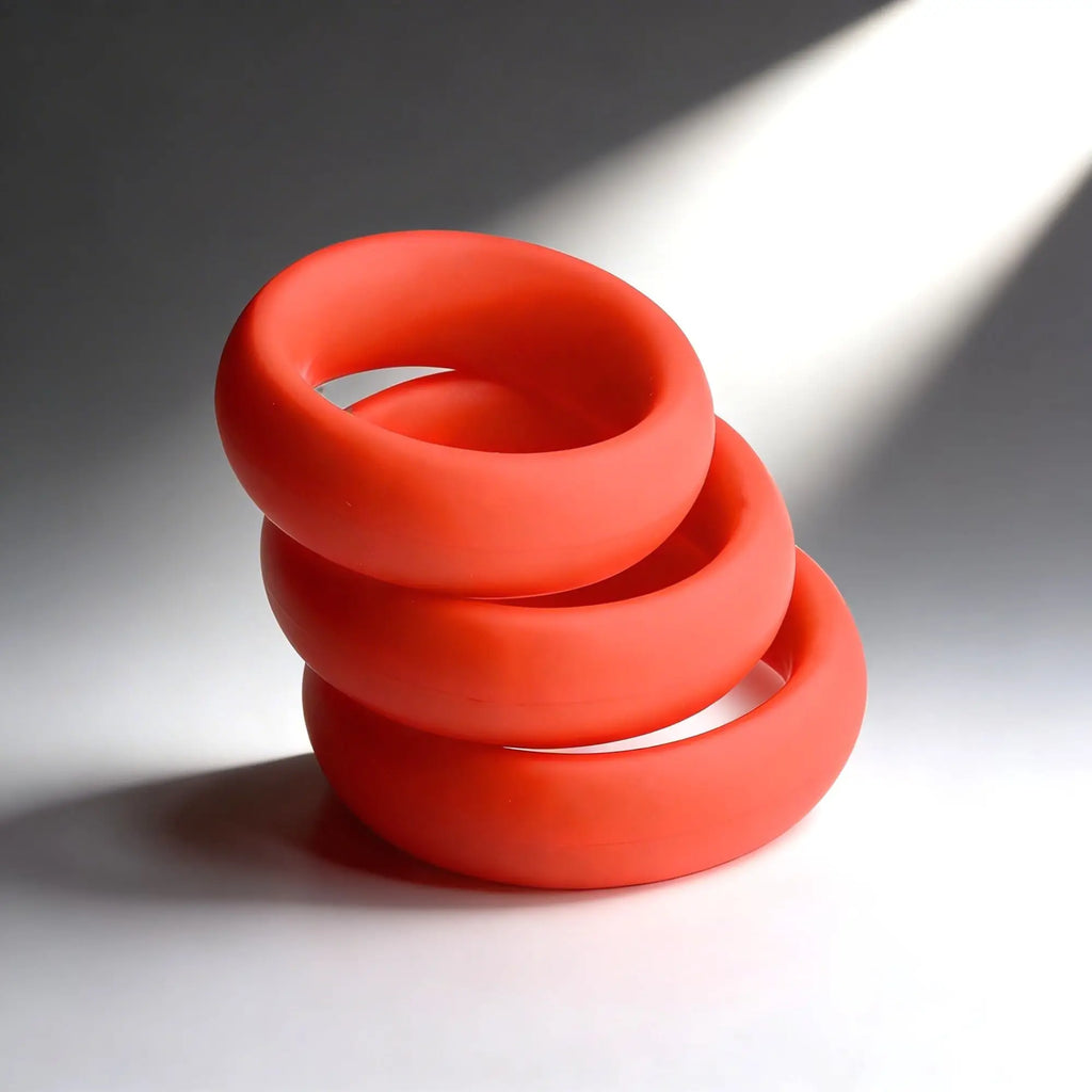 Trinity Men Fat Silicone Cock Ring 3-pack: three stackable, smooth, bright orange, thick silicone rings.