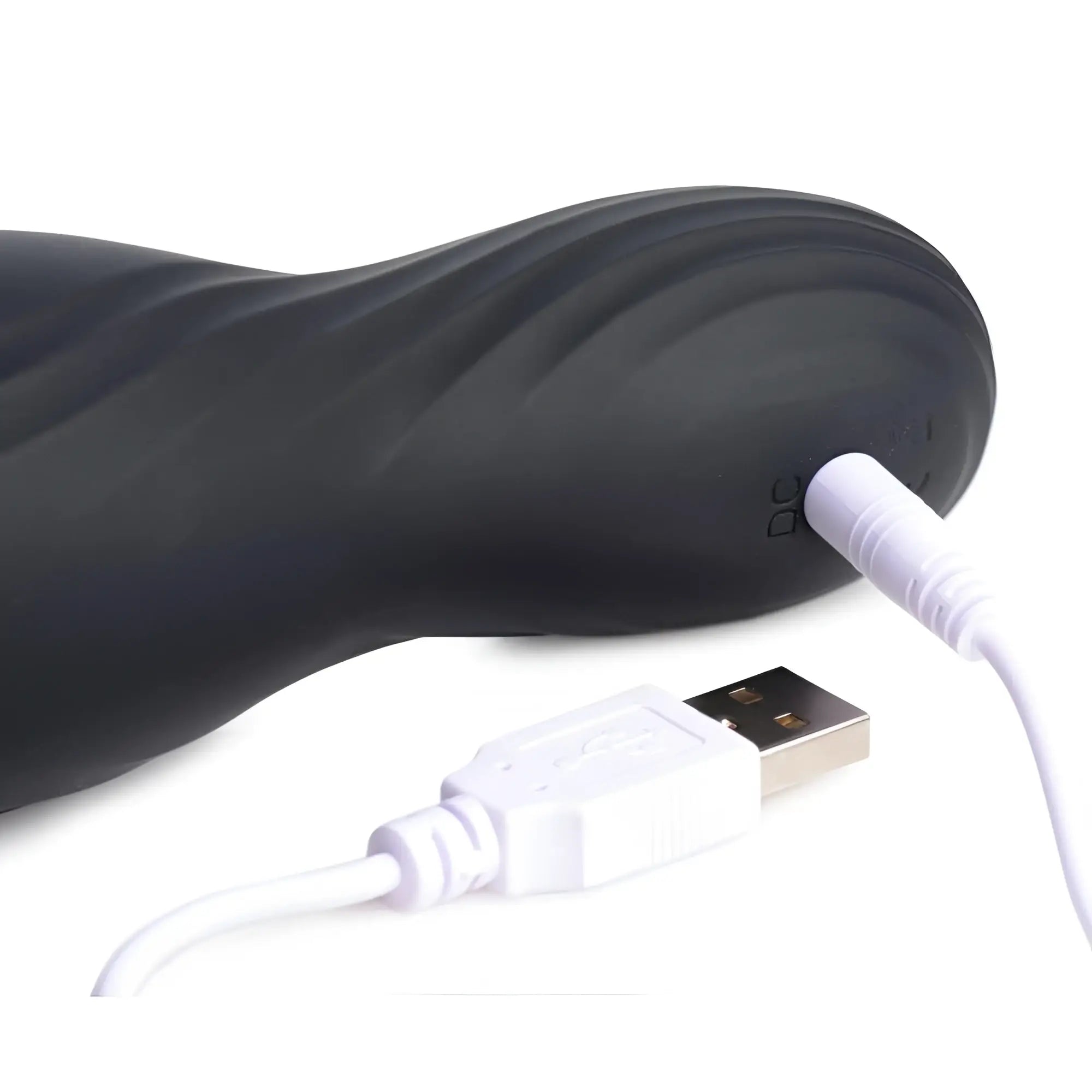 Trinity Men Vibrating Rechargeable Penis Pleaser: A matte black, contoured device being charged via a white USB cable.