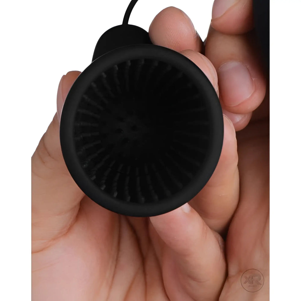 Trinity Vibes 10 Speed Silicone Penis Head Teaser: A black, cup-shaped device with ribbed interior held in a hand.