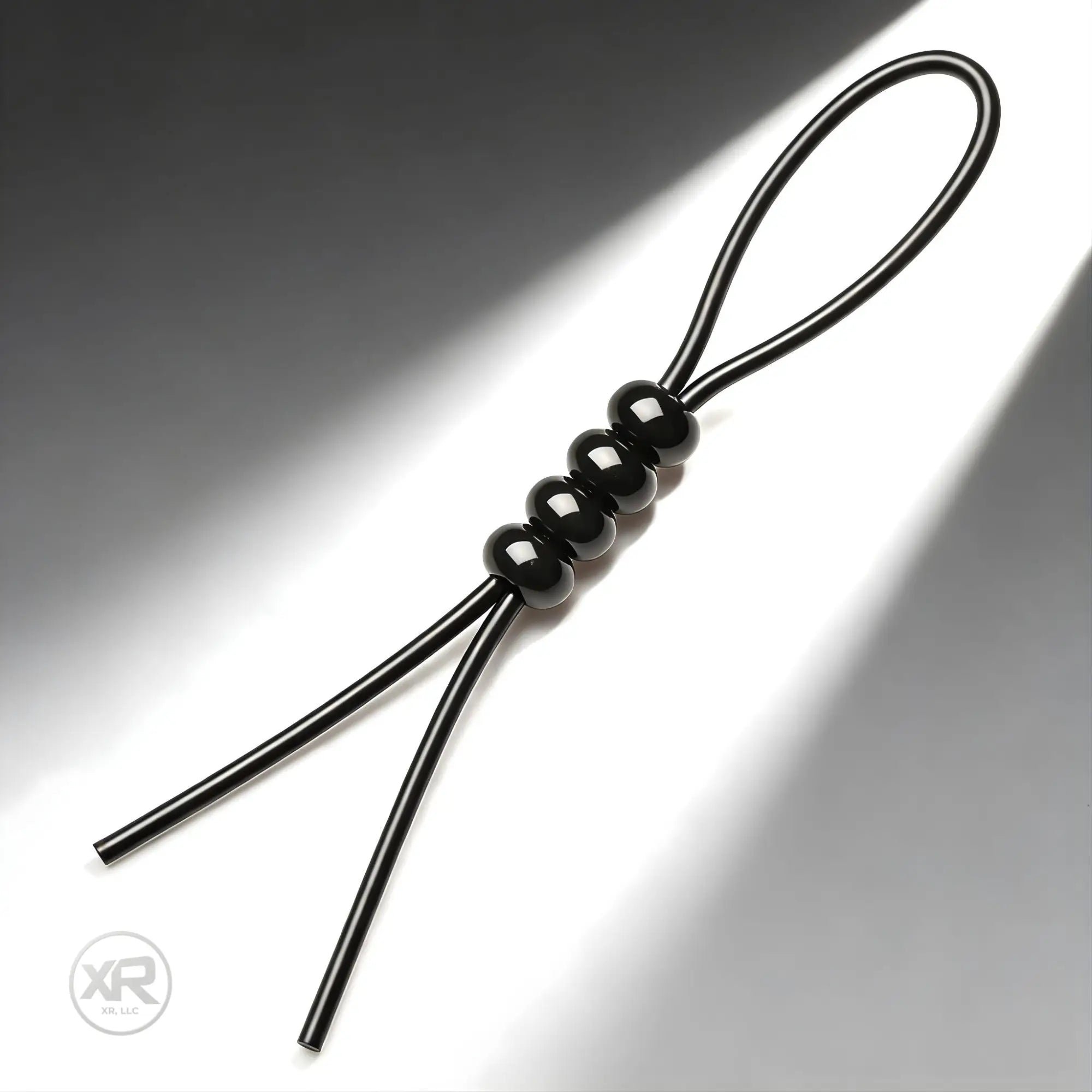 Trinity Vibes 4-Way Adjustable black silicone tie with a looped cord and four adjustable, smooth spherical beads.