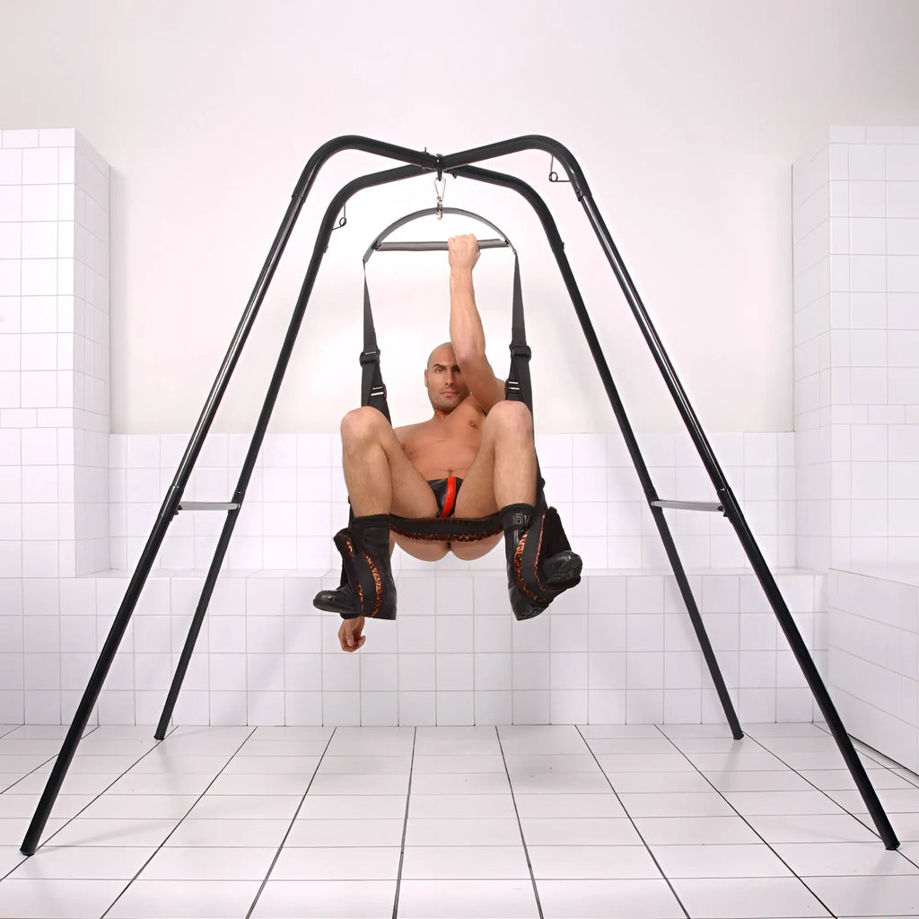 Trinity Vibes Trinity Sex Swing Stand featuring a black metal frame and an adjustable harness seat for suspension.