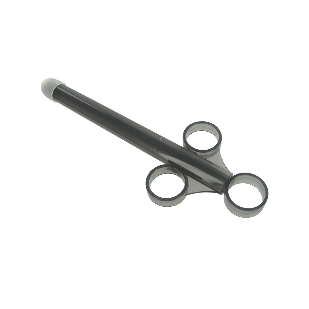 Trinity Vibes XL Lubricant Launcher: A translucent black syringe-style tool with three finger rings, white tip.