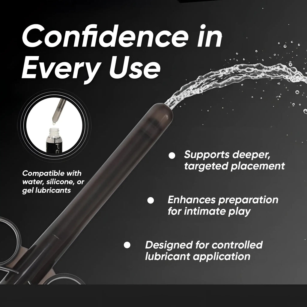 Trinity Vibes XL Lubricant Launcher: a sleek black syringe-style applicator ejecting a stream of liquid on black background.